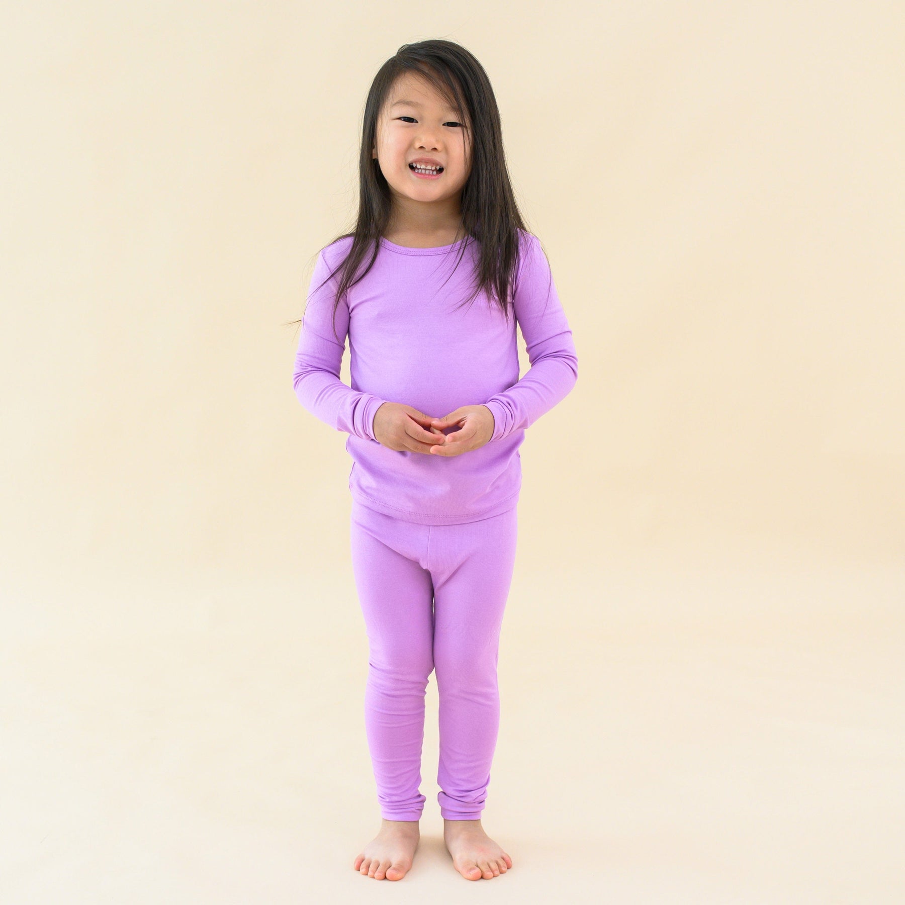 toddler modeling long sleeve pajamas in poi 