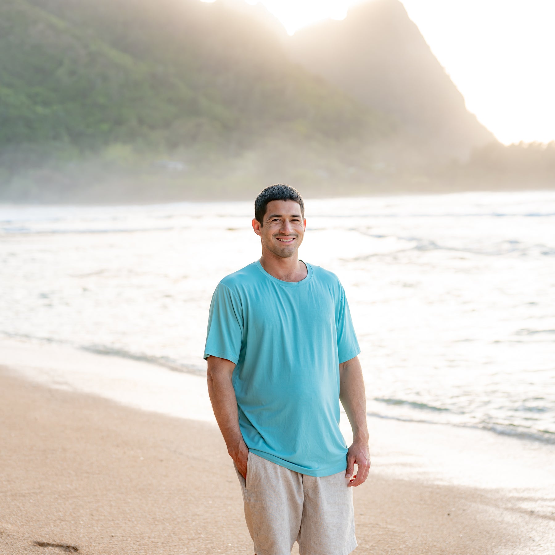 Man modeling Men's Crew Neck Tee in Makai on beach