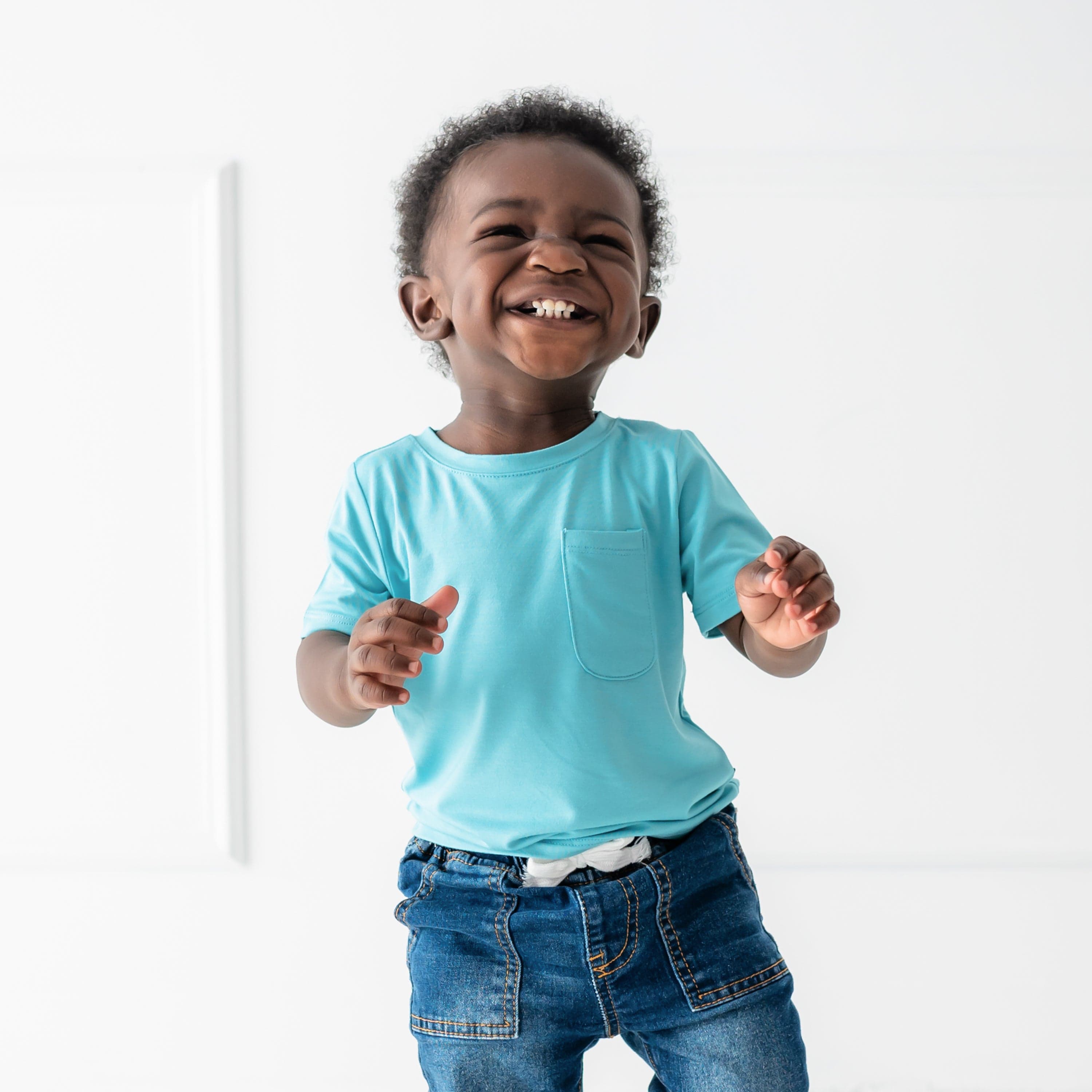 toddler smiling and wearing short sleeve crew neck tee in makai