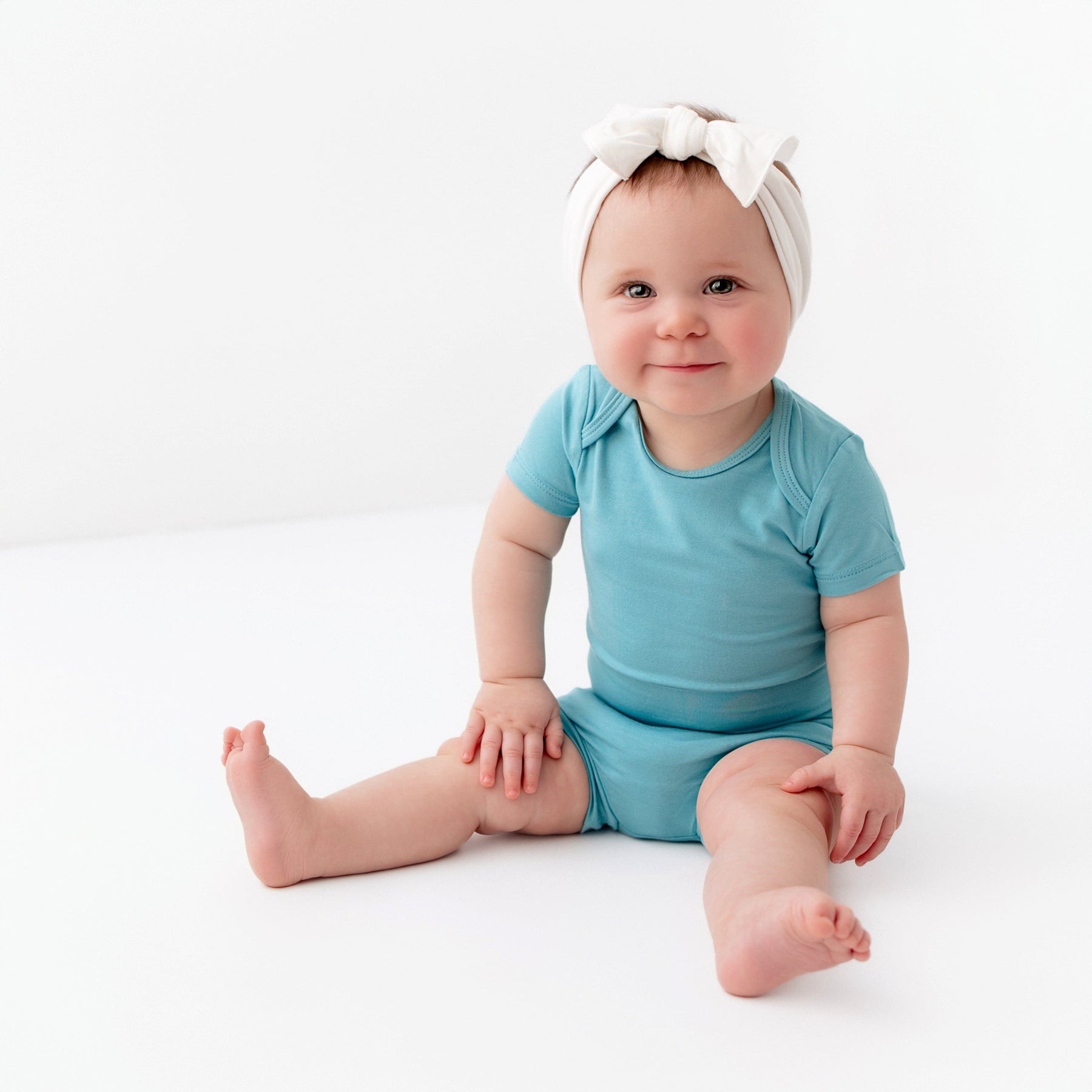 baby wearing kyte baby bodysuit and bummies in makai