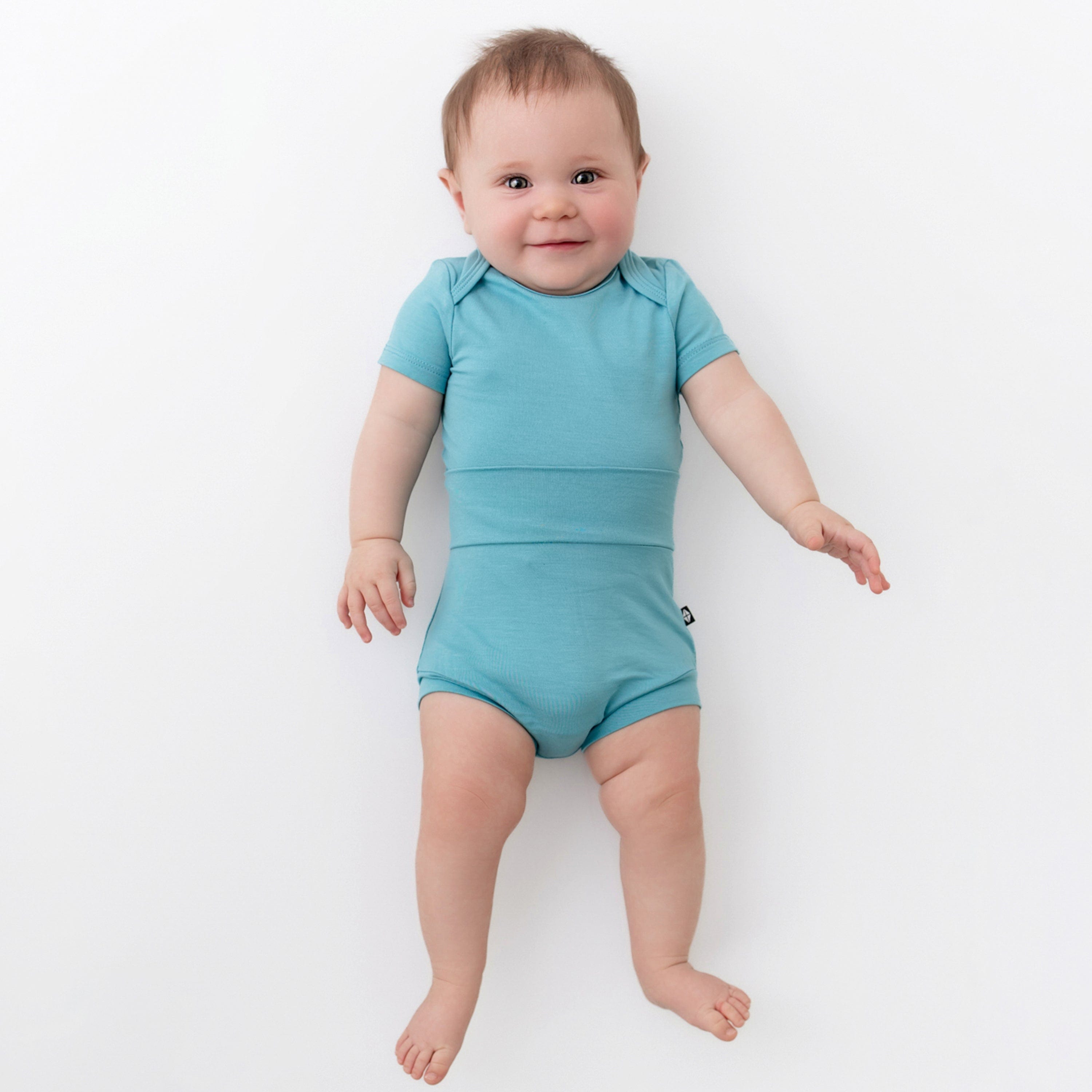 baby wearing kyte baby bodysuit and bummies in makai