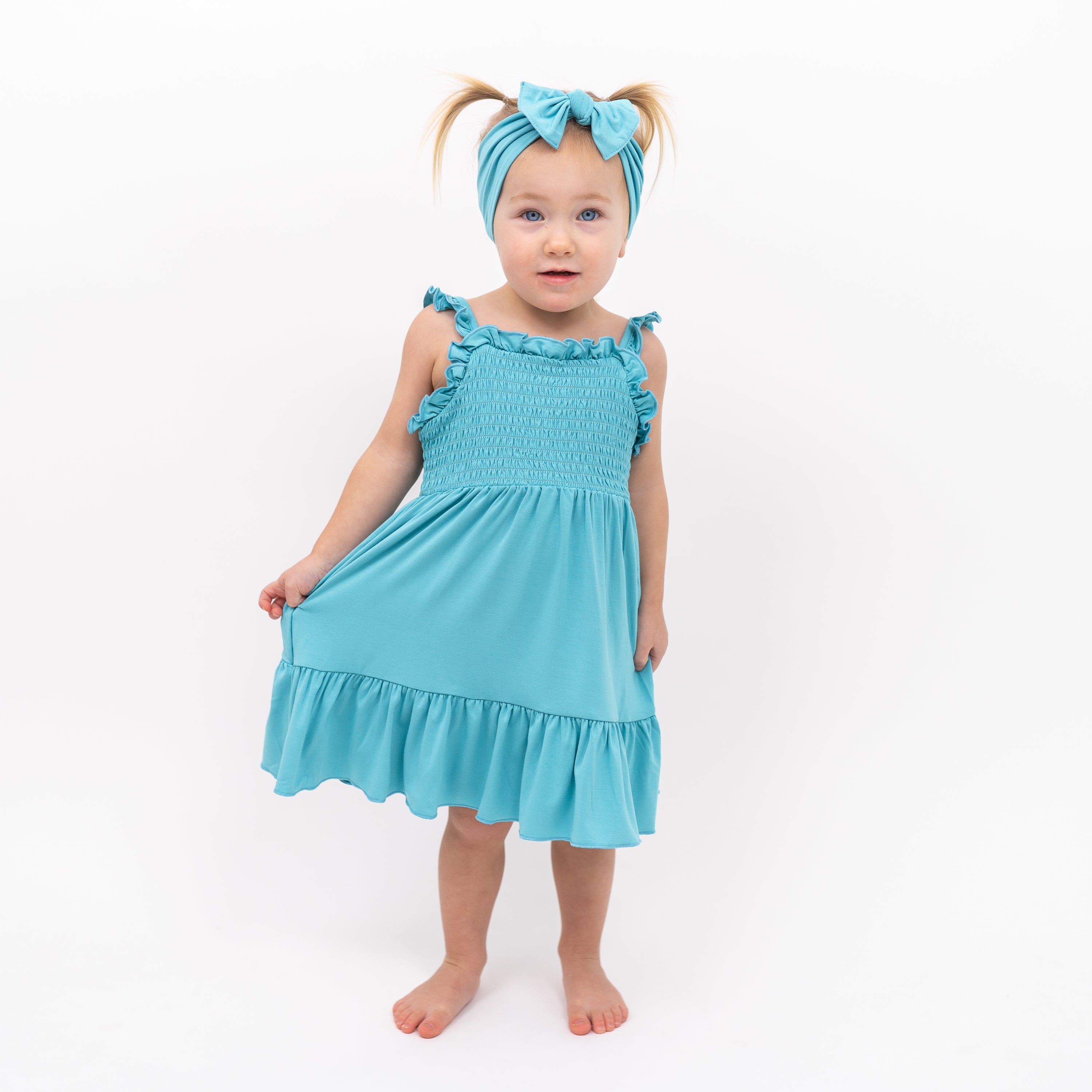 Toddler modeling Smocked Dress in Makai