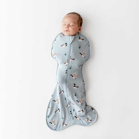 Sleeping newborn wearing the Swaddle Bag in Mallard Duck 0.5