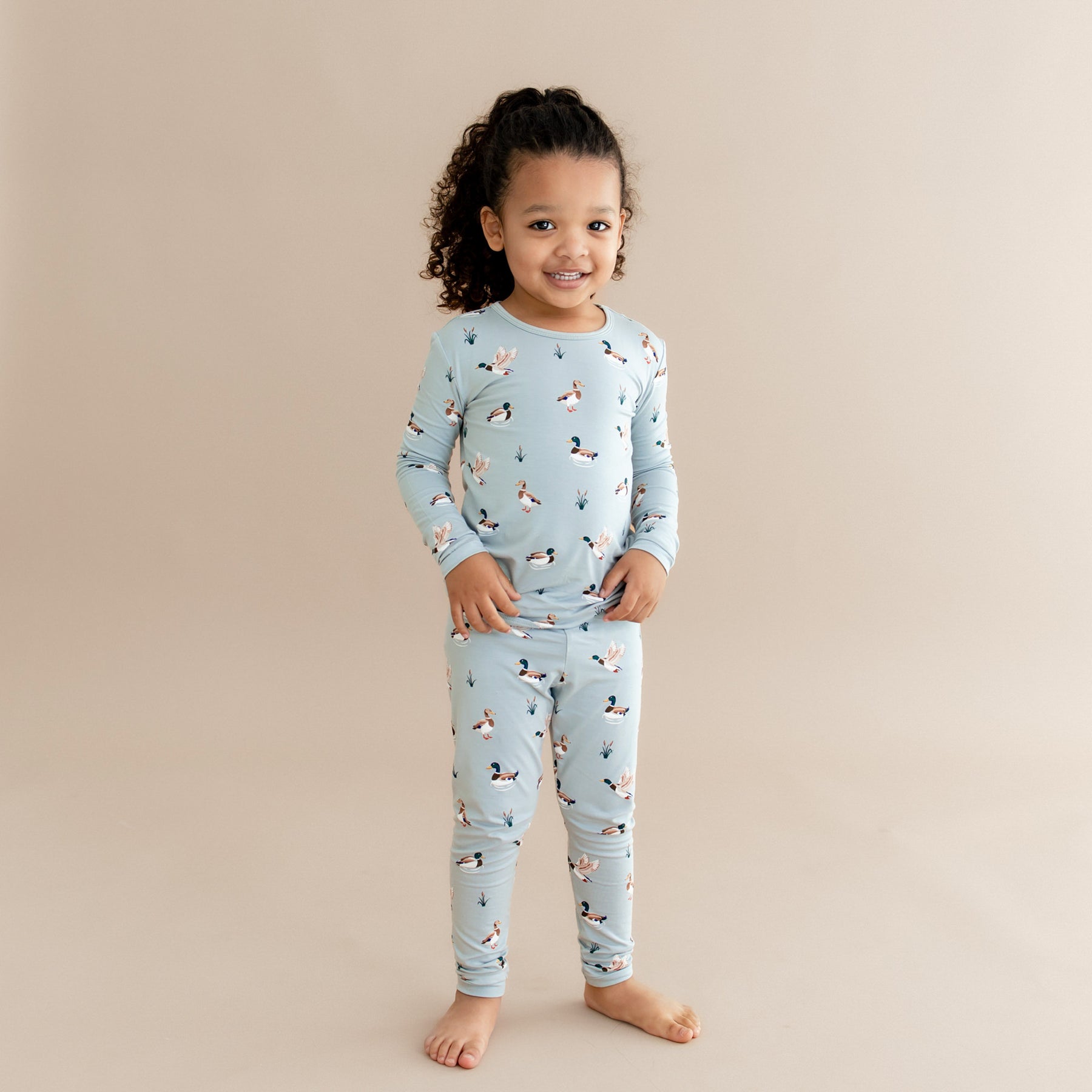 Young smiling girl wearing the Long Sleeve Pajamas in Mallard Duck