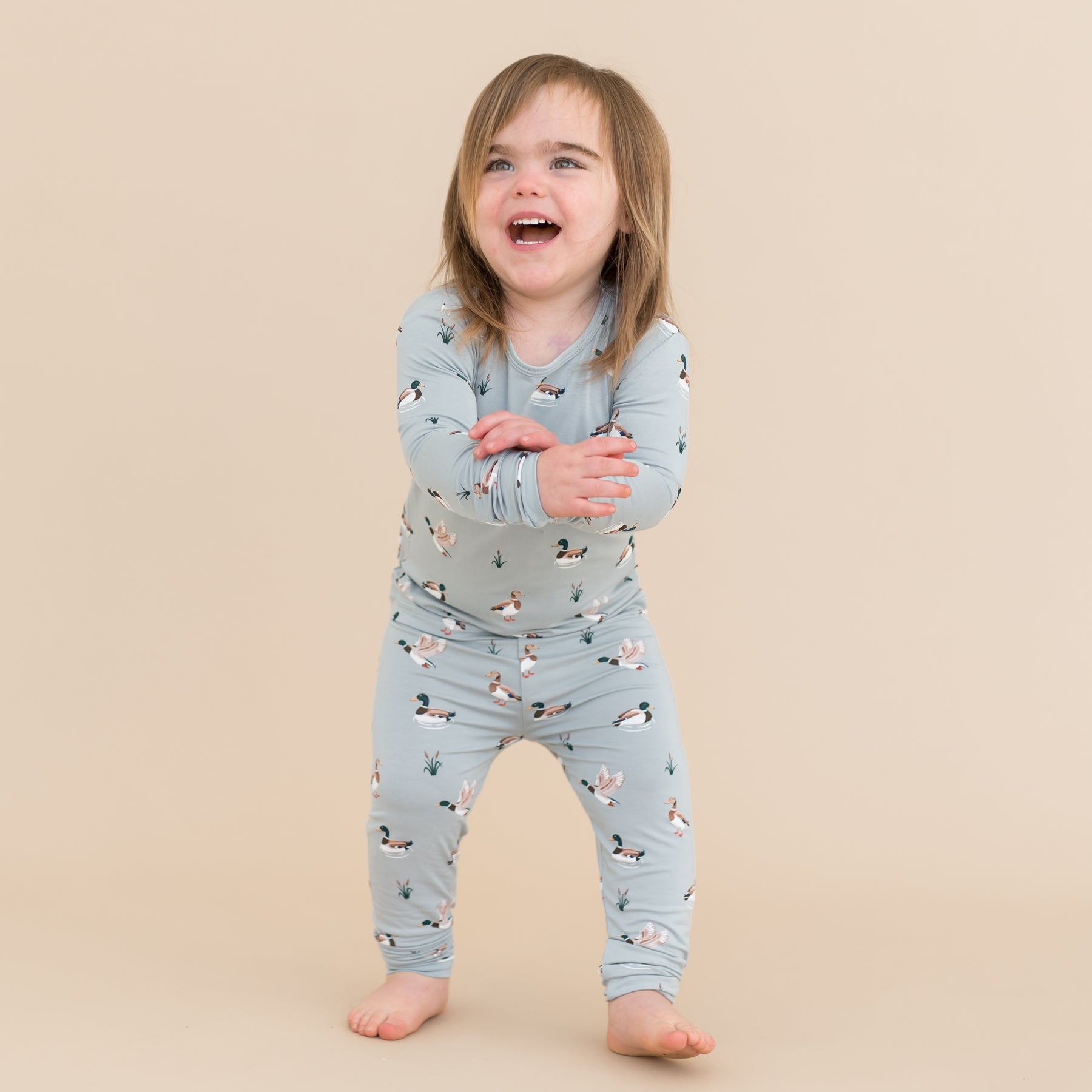 Young smiling child wearing the Long Sleeve Pajamas in Mallard Duck