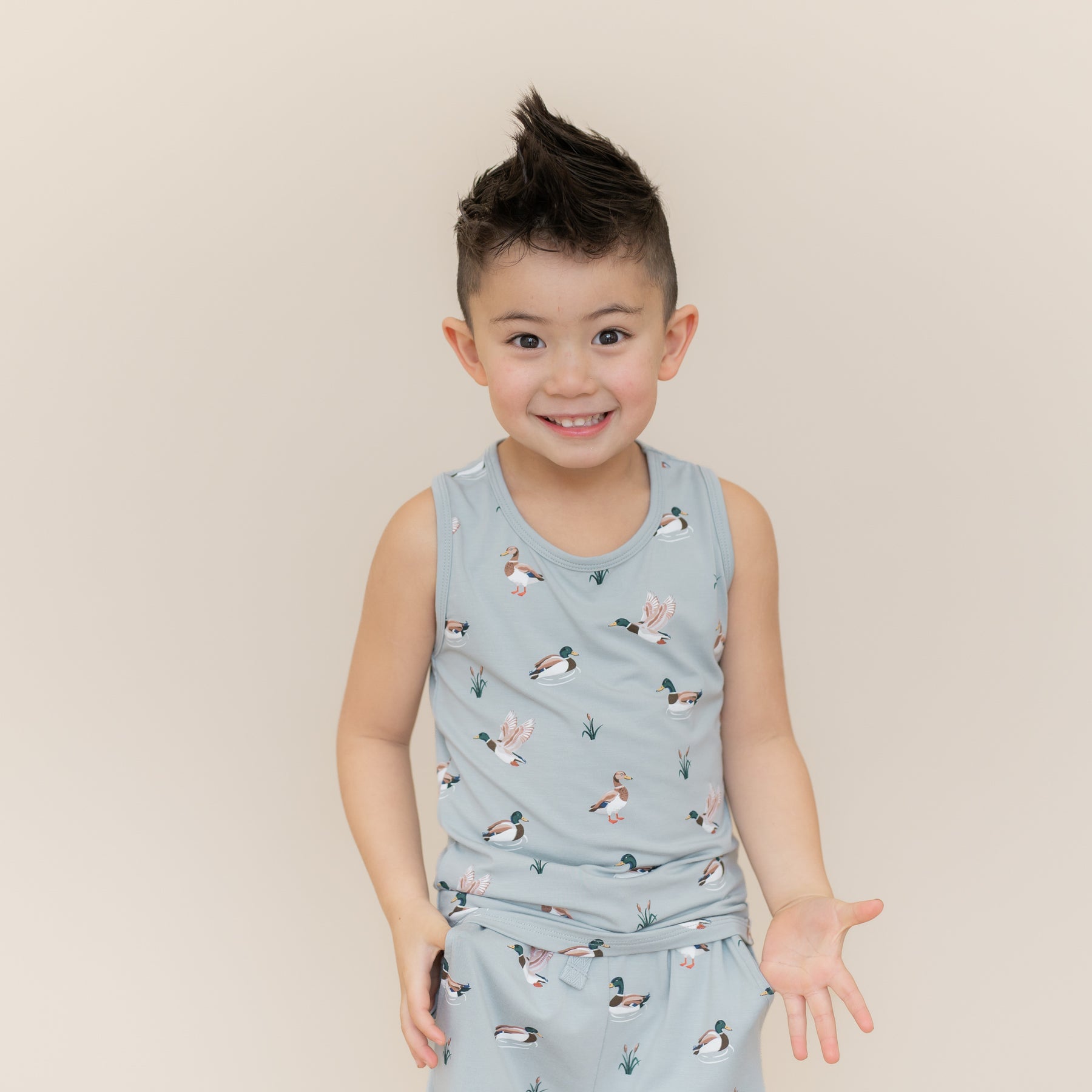 Smiling boy wearing the Toddler Tank Top in Mallard Duck with matching drawstring shorts