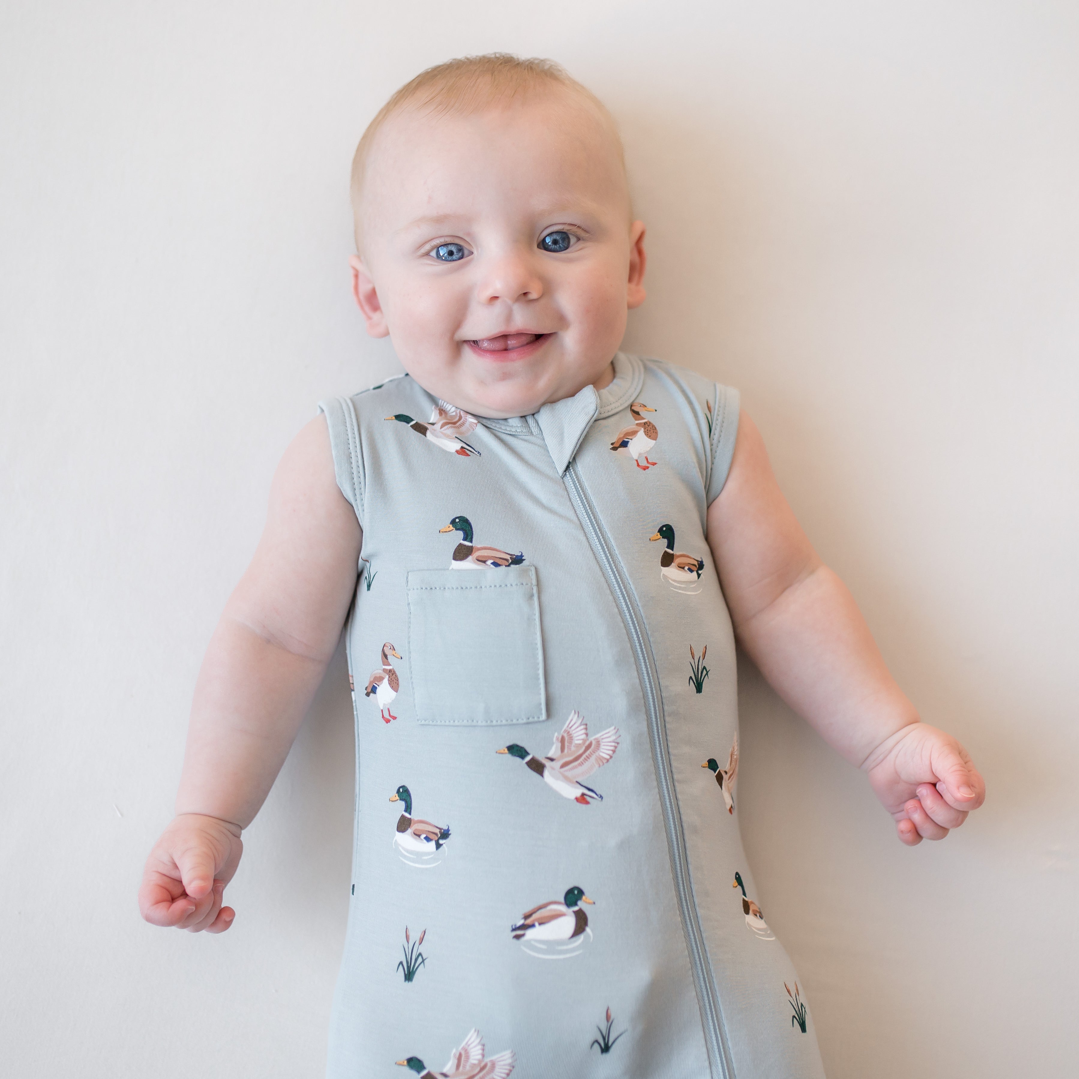 Close up of an infant wearing the Zippered Sleeveless Romper in Mallard Duck