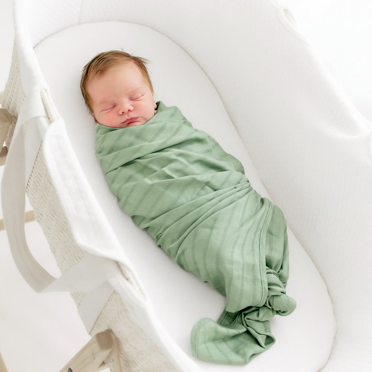 Newborn swaddled in Bamboo Muslin Swaddle Blanket in Matcha