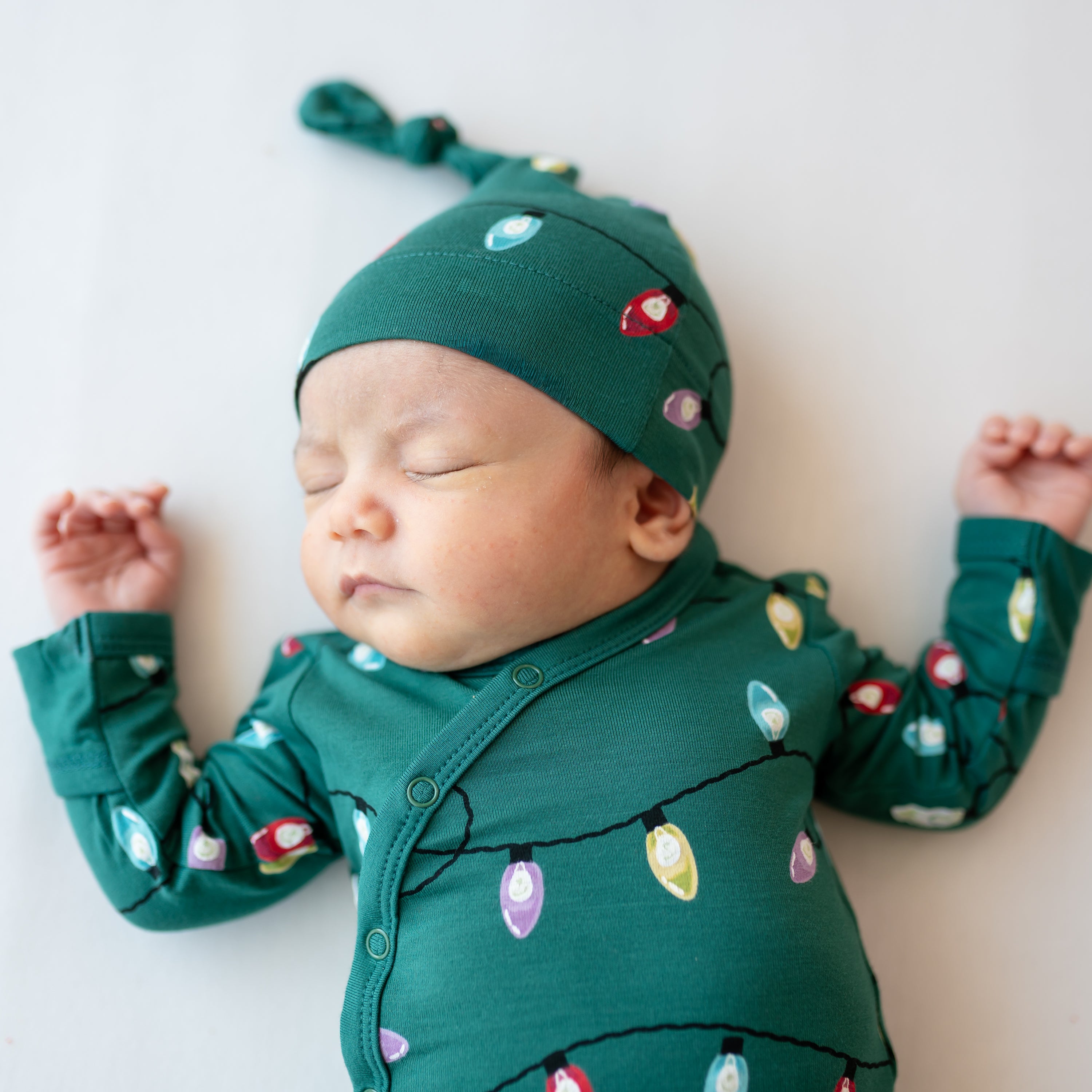 Close up of the snap closure on the Take Me Home Set with Cap in Merry and Bright shown on a sleeping newborn