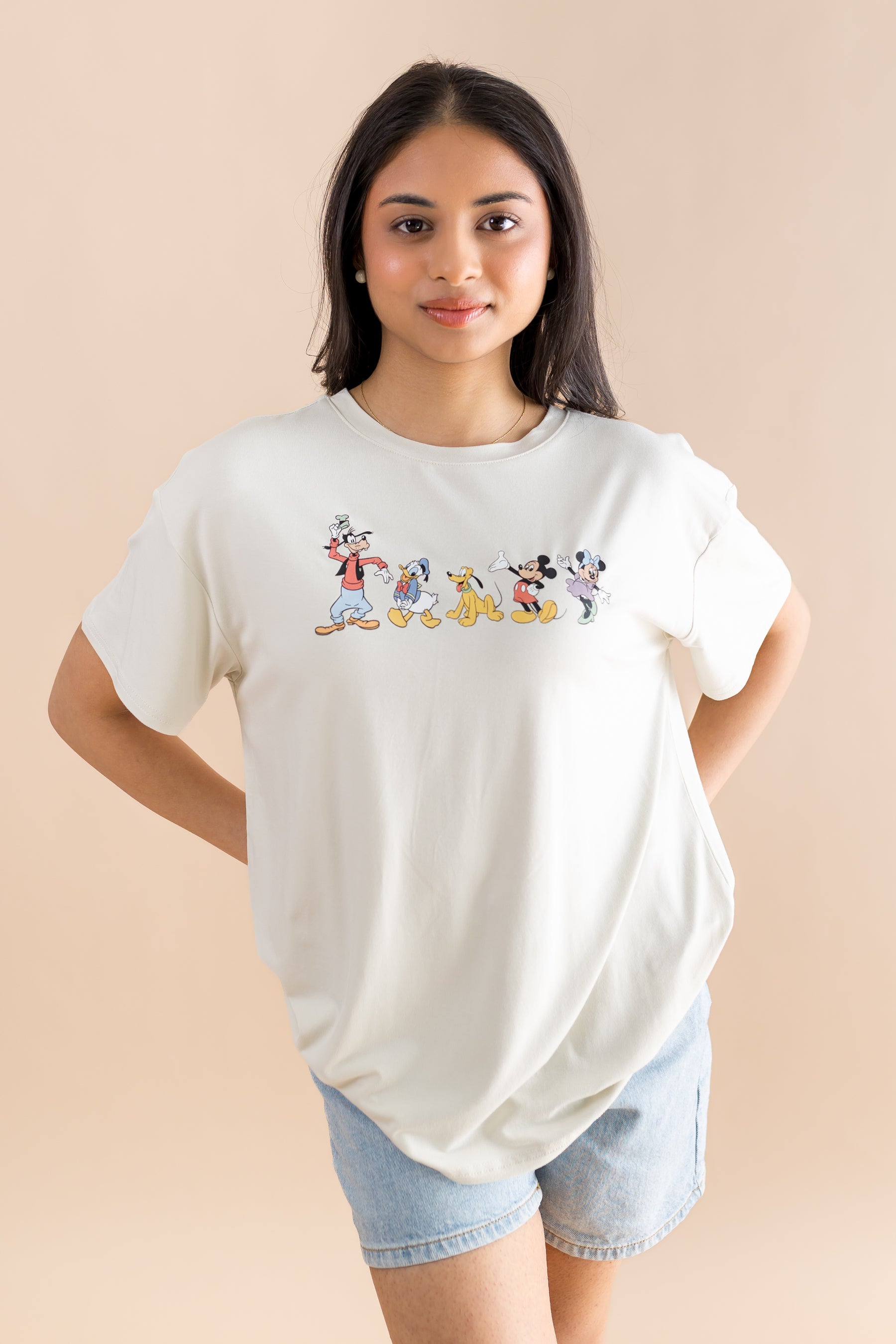 Woman wearing shorts and graphic tee with mickey and friends 