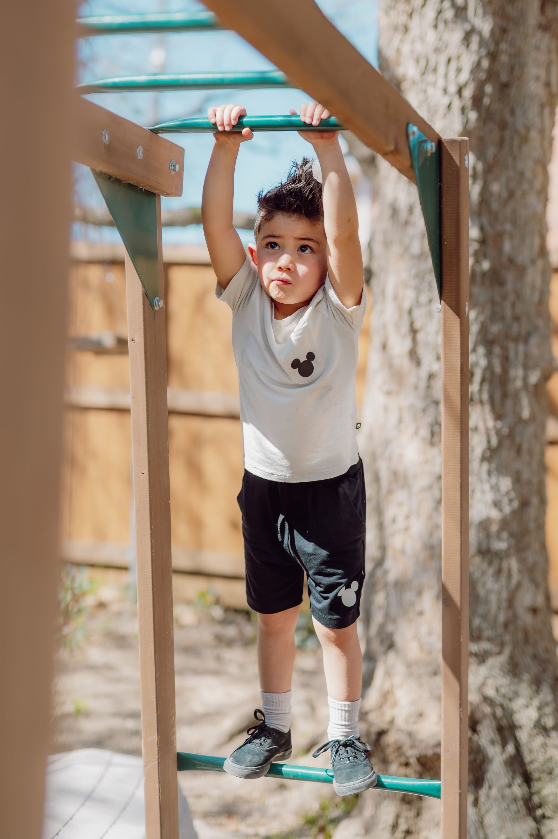 Child on a playground monkey bar with a natural background