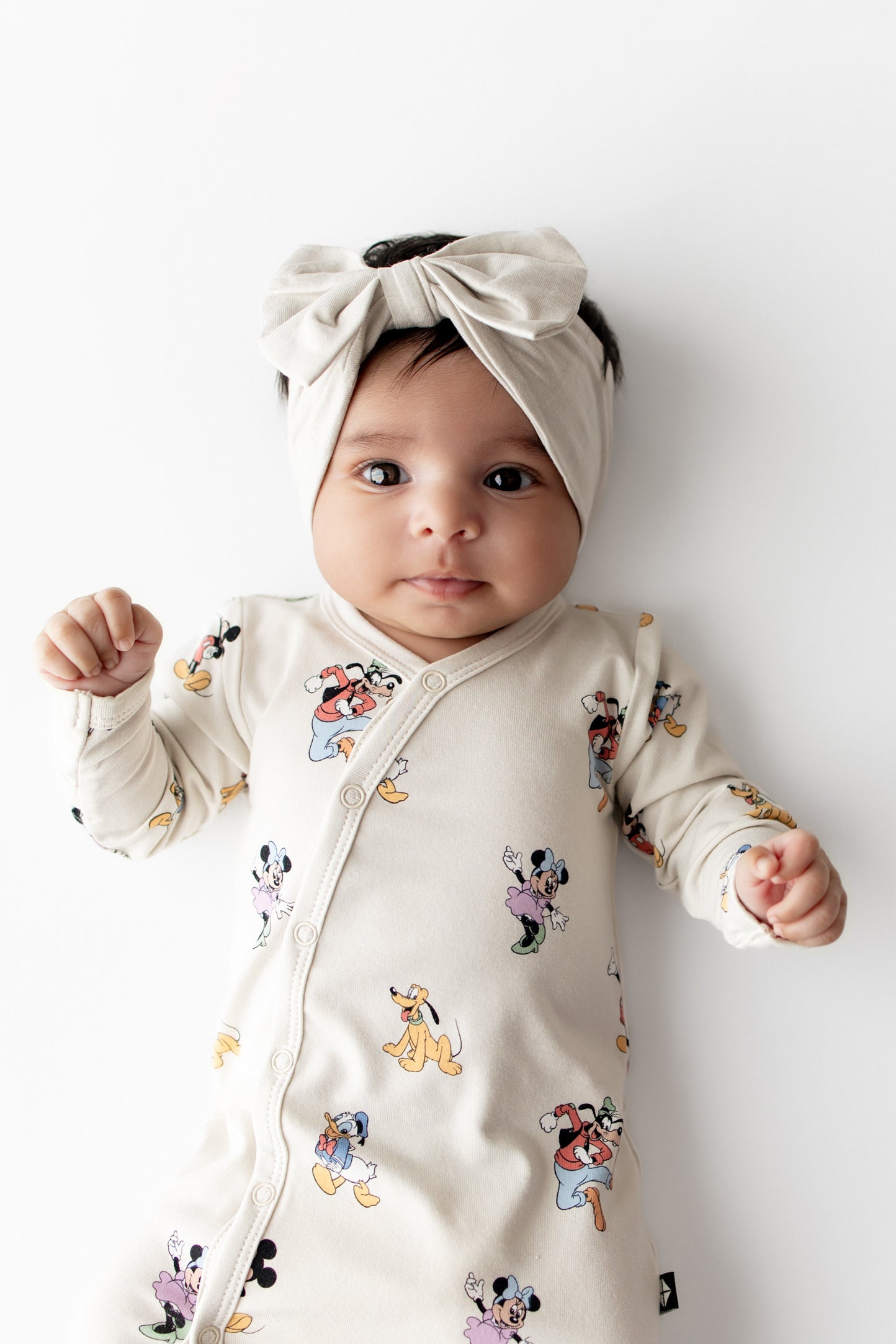 Baby in Mickey Mouse and Friends bundler and cream bow