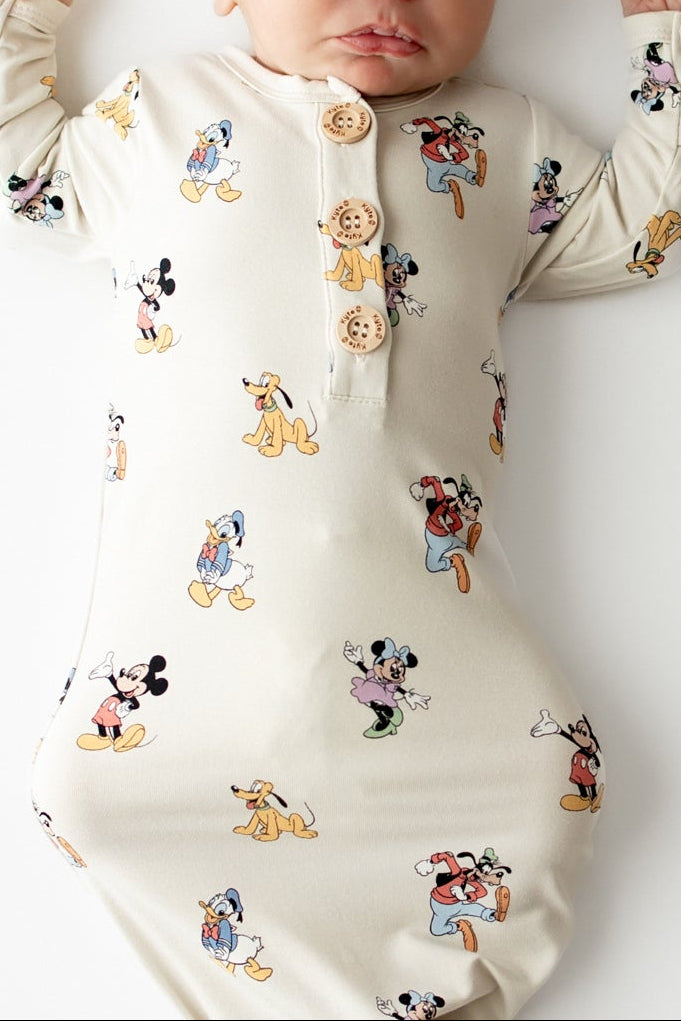 Baby asleep in a mickey character pattern gown with matching cap