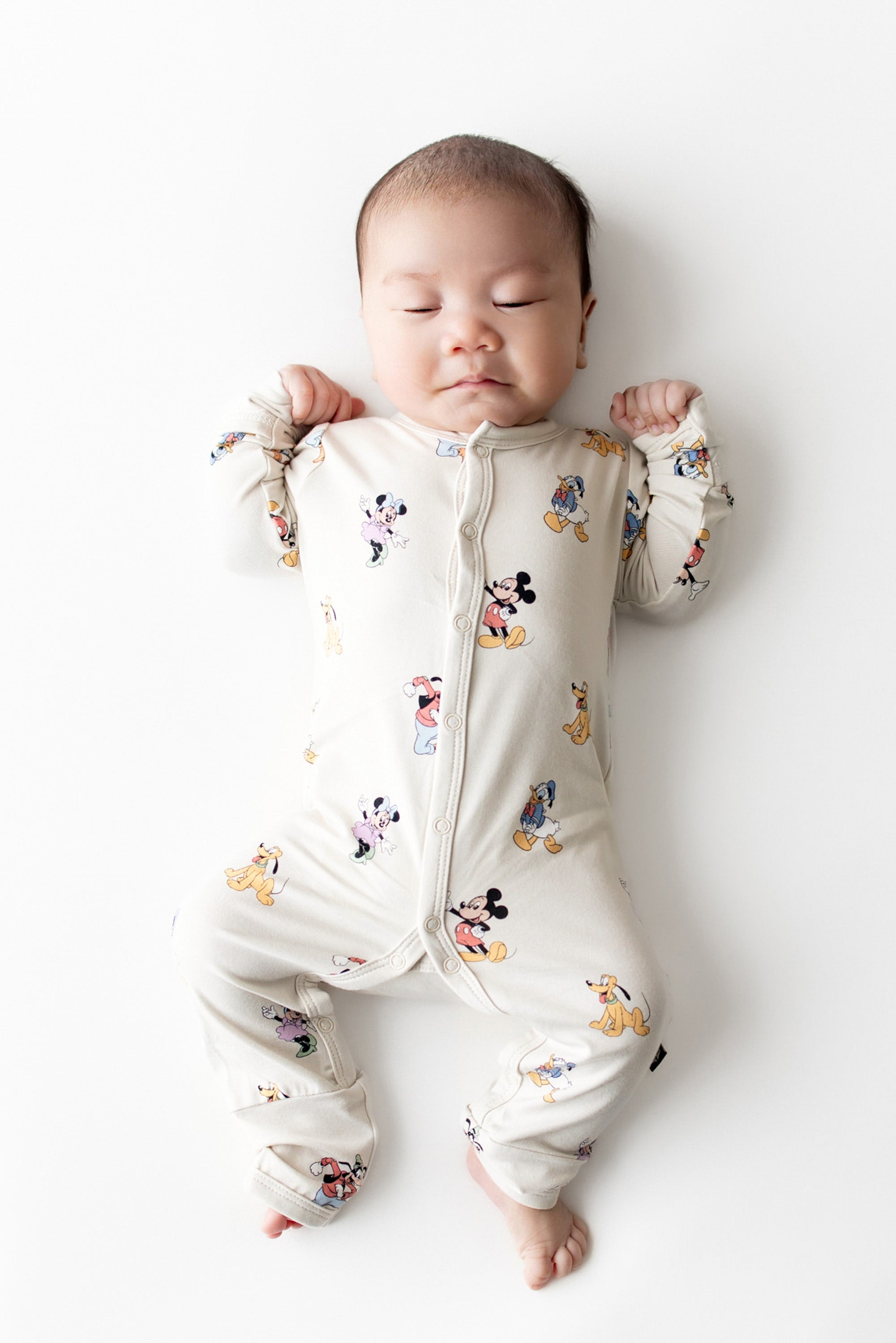 Baby sleeping a snap romper with mickey and friends pattern