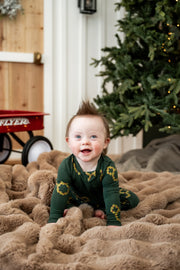 Baby wearing Zippered Romper in Mickey Christmas Wreath print sitting on a beige blanket