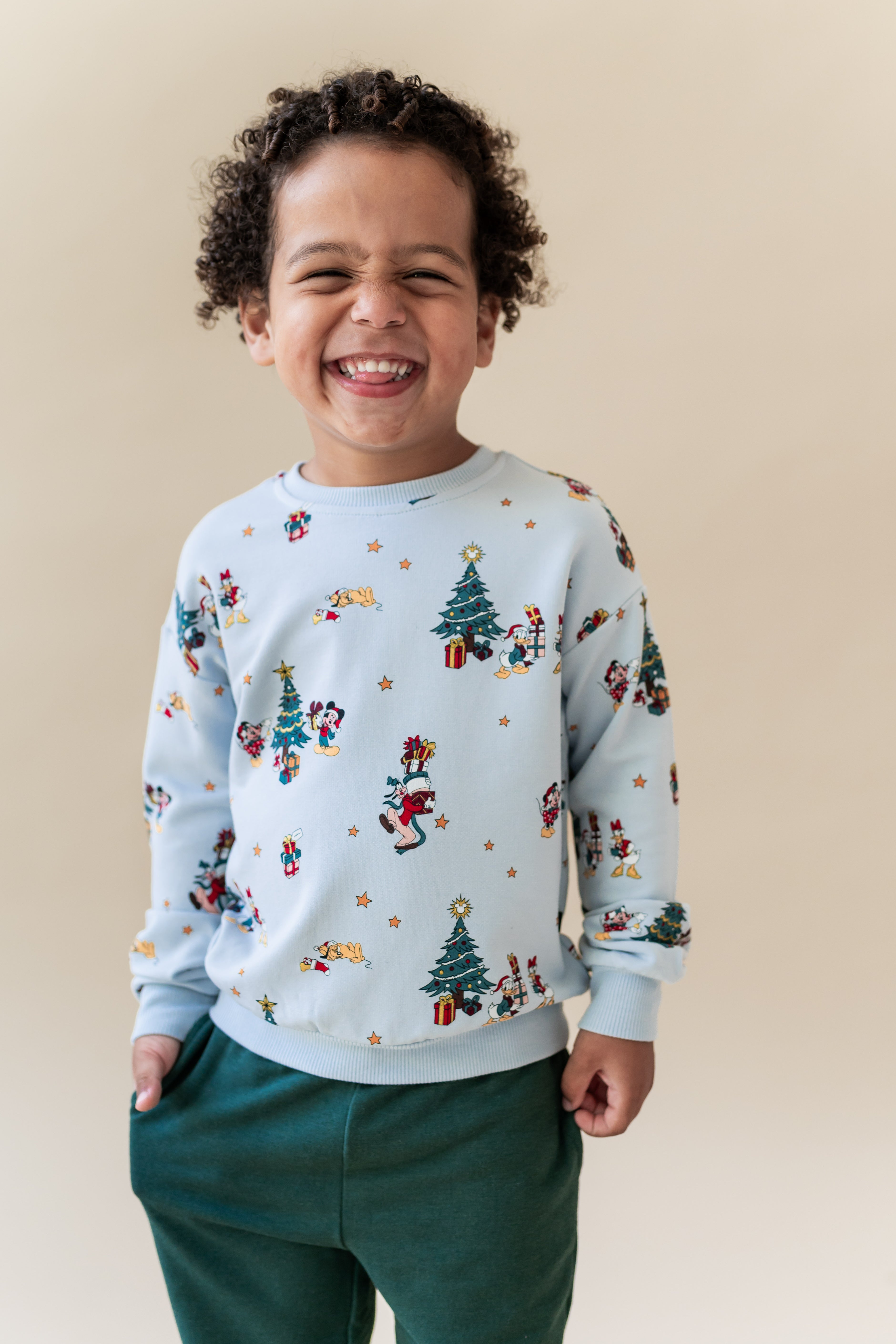 Boy wearing Sweatshirt in Mickey & Friends Christmas print over green pants
