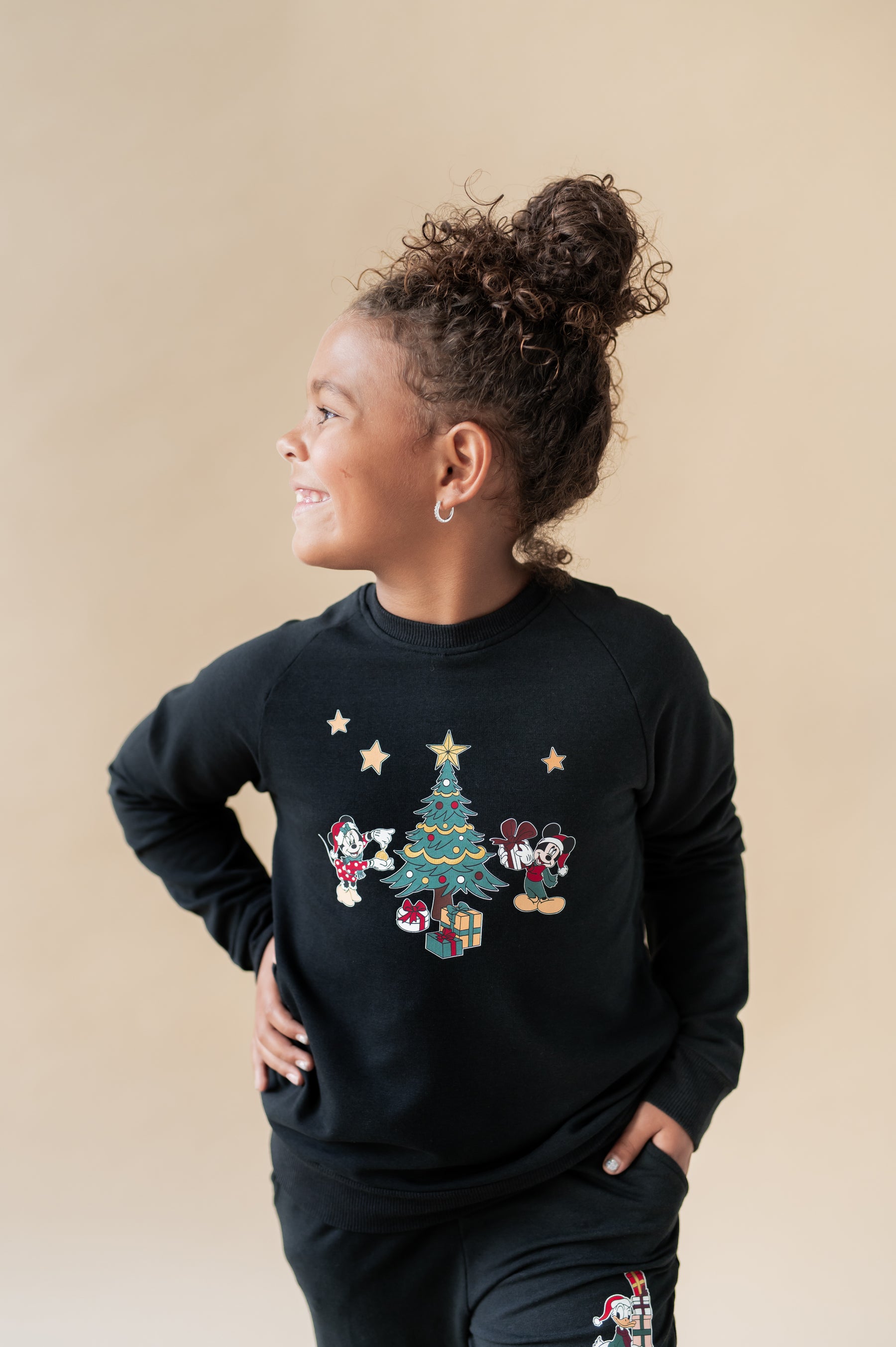 Girl wearing Long Sleeve Jogger Set in Mickey & Friends Christmas print on Midnight color on a beige background
