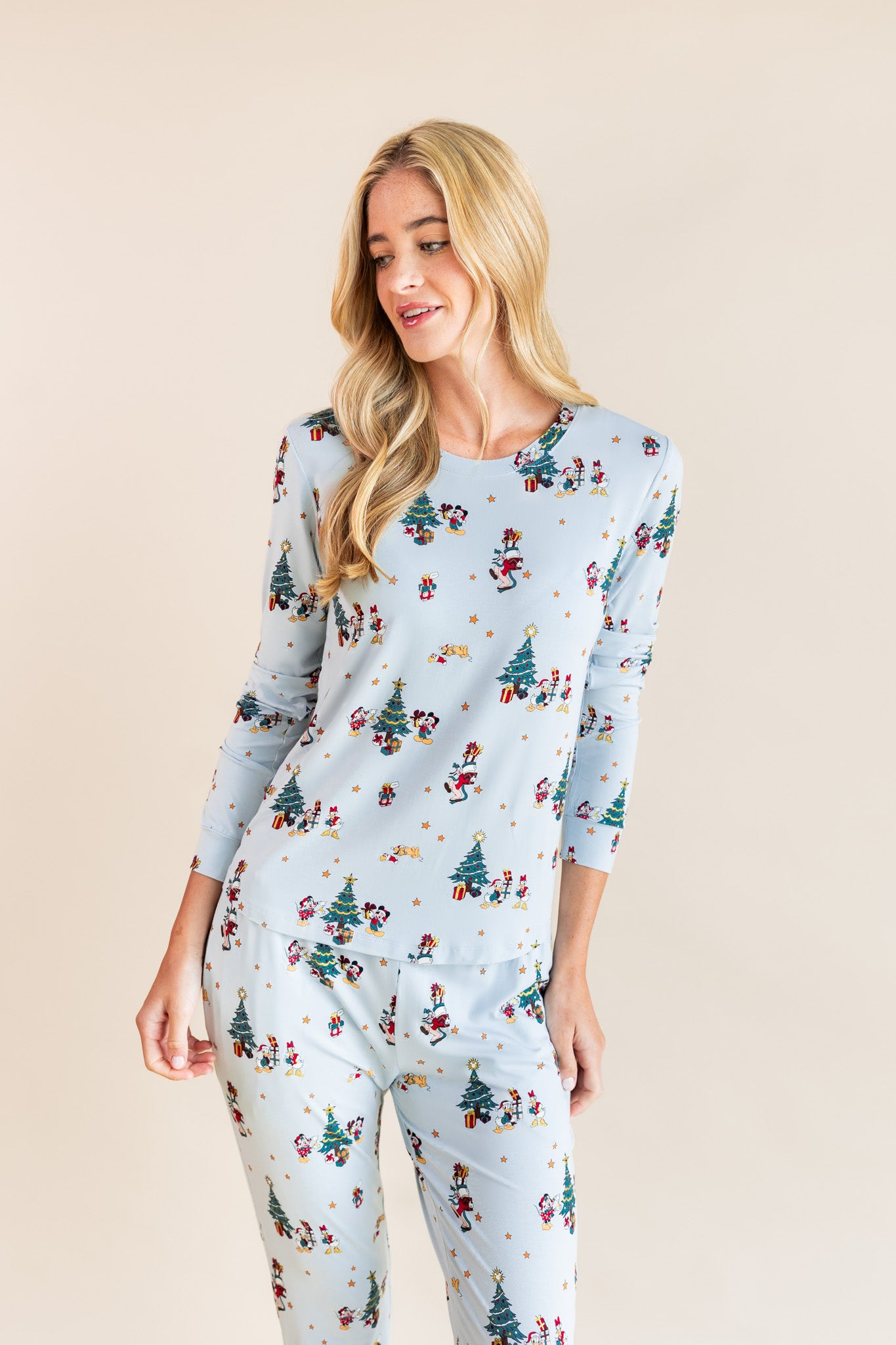 Woman wearing Women's Jogger Pajama Set in Mickey & Friends Christmas print on a beige background