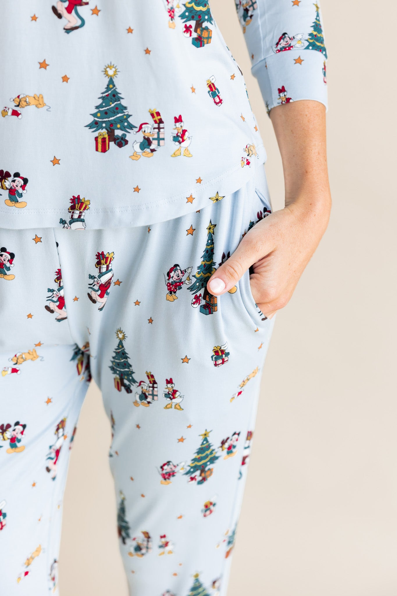 Modal showcasing the pockets on Women's Jogger Pajama Set in Mickey & Friends Christmas print on a beige background