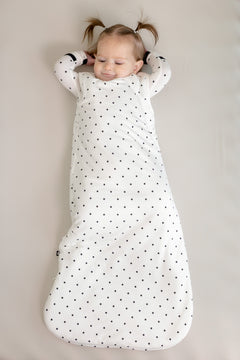Baby wearing Sleep bag in Midnight Polka Dot print on a beige background