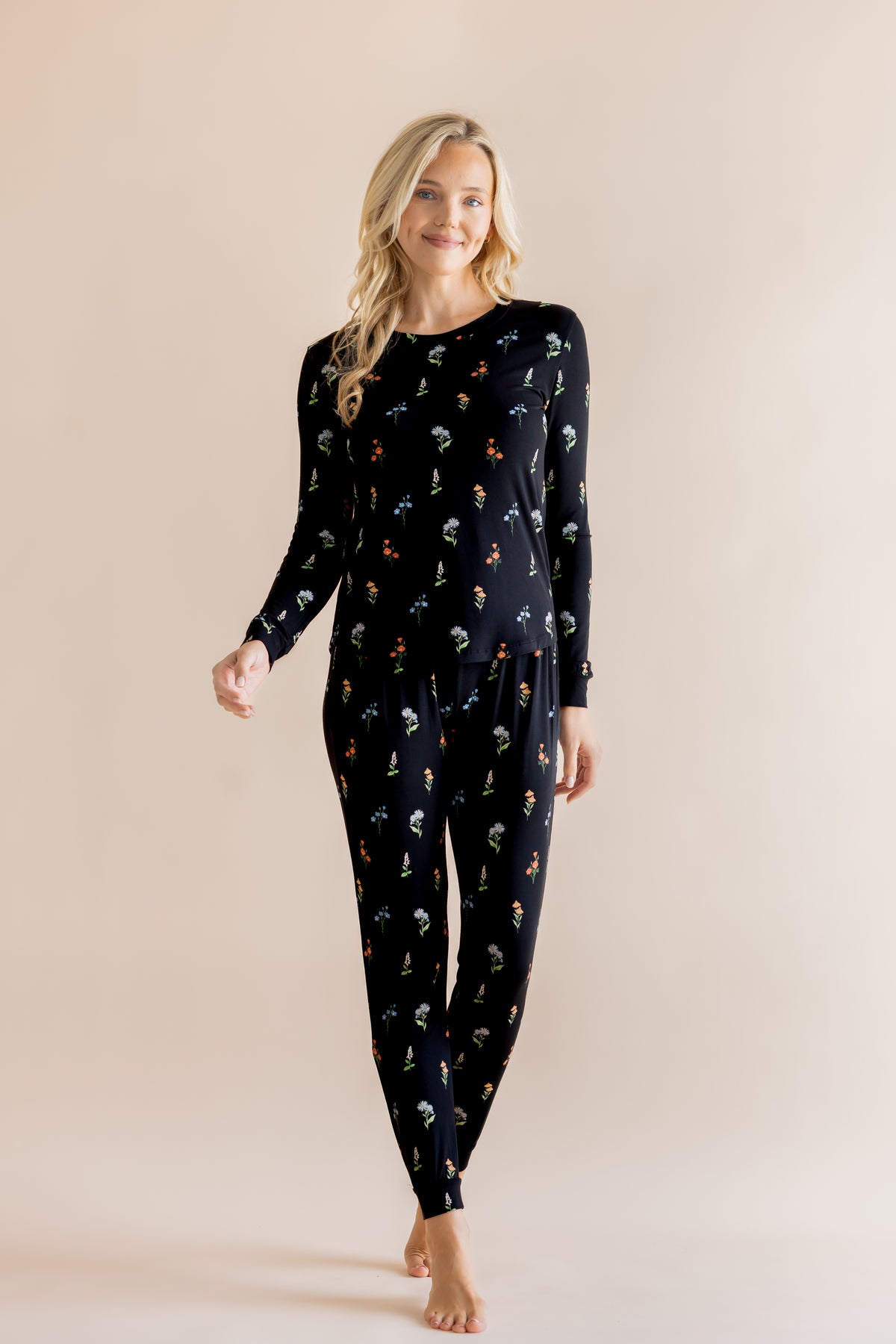 Model wearing Women's Jogger Pajama Set in Midnight Wildflower print on beige background