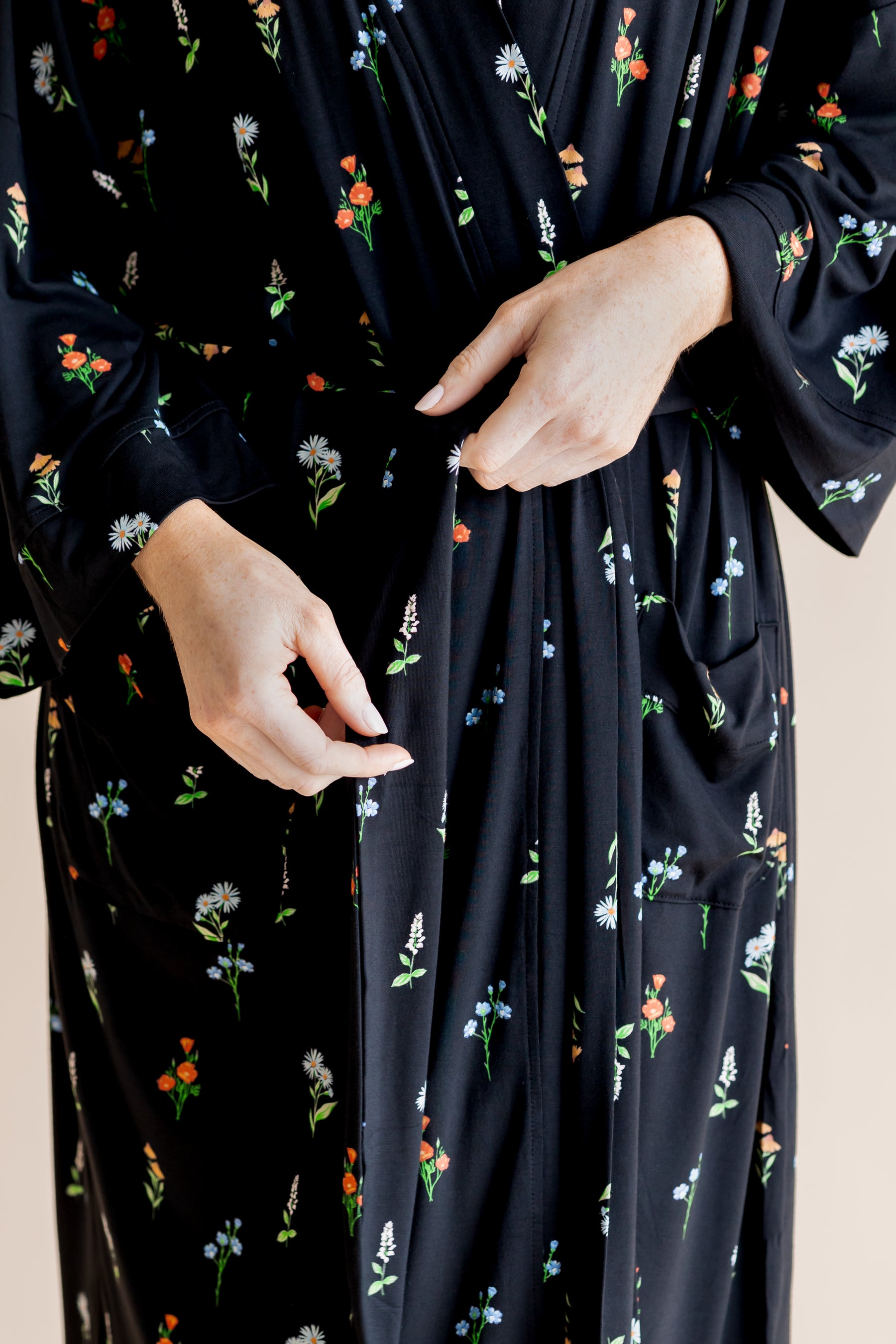 Model showcasing the front of Women’s Kimono Robe in Midnight Wildflower print on a beige background