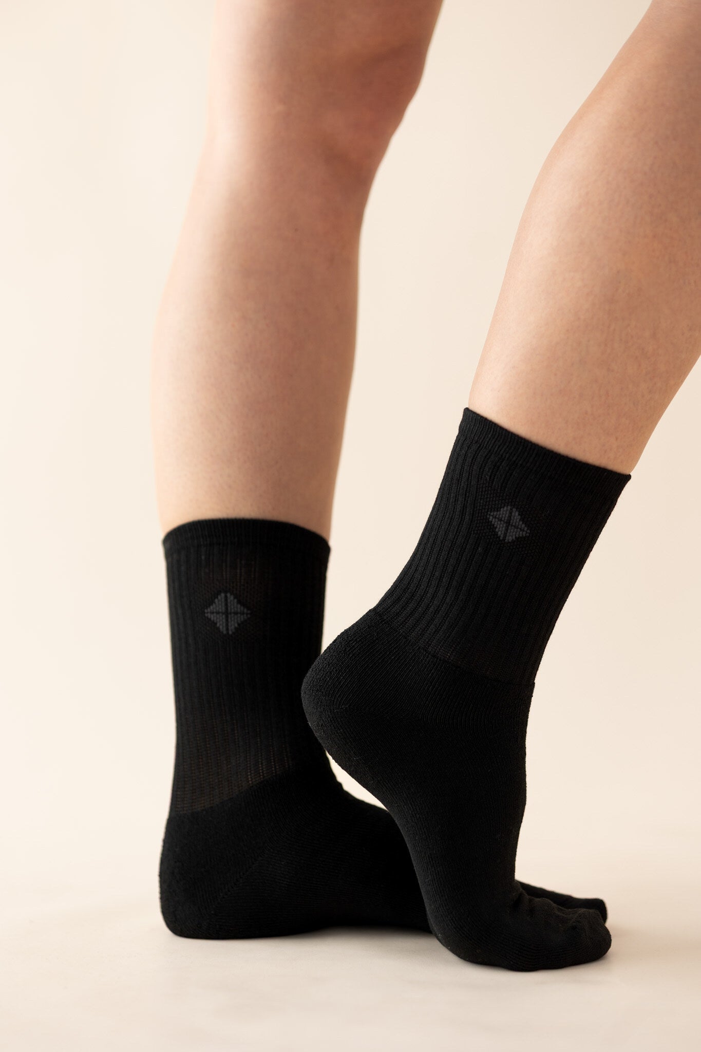 Adult Crew Socks in Midnight with the logo visible shown on models feet