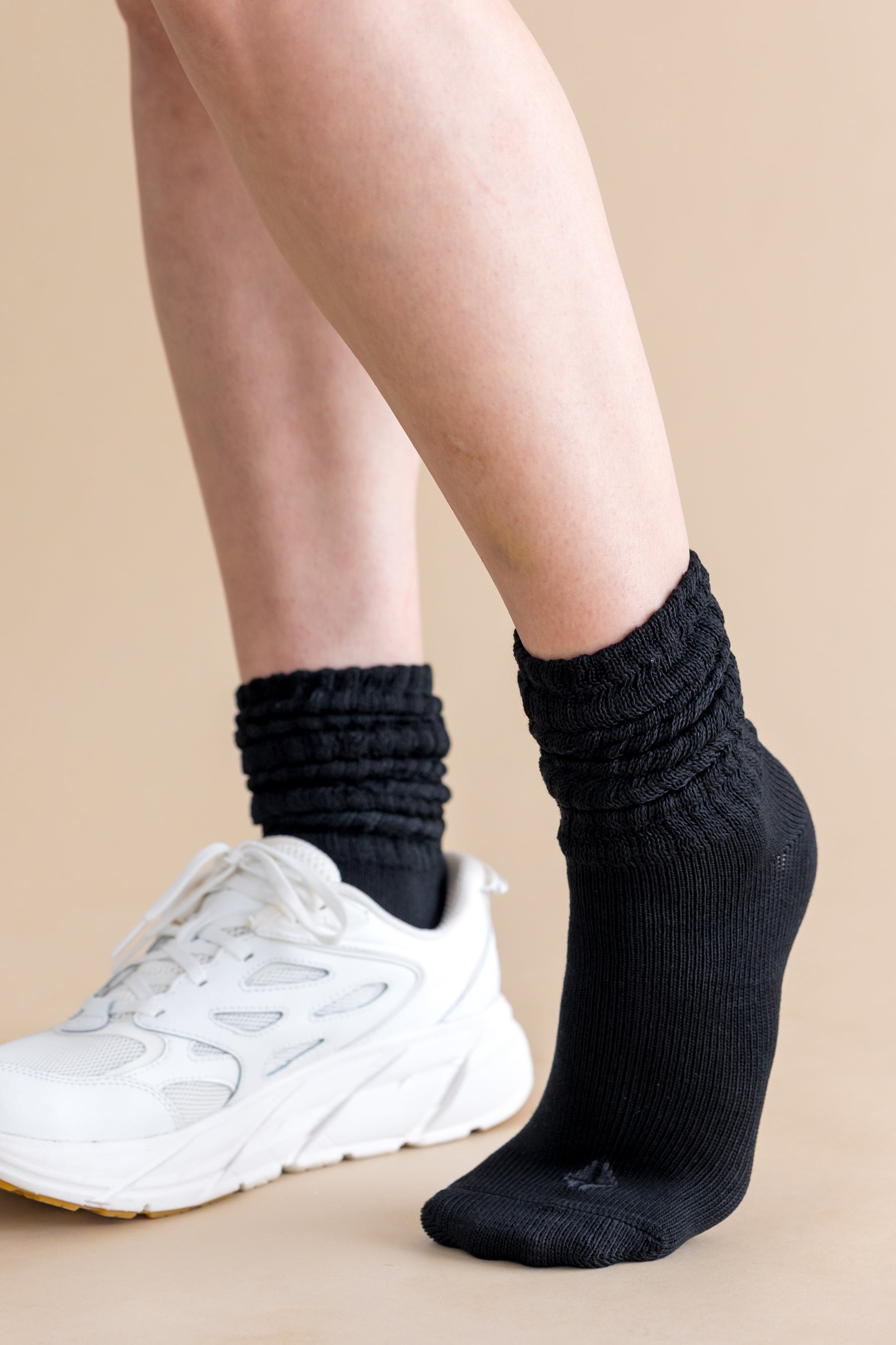 Adult Scrunch Socks in Midnight shown on a models feet with a white sneaker on the right foot