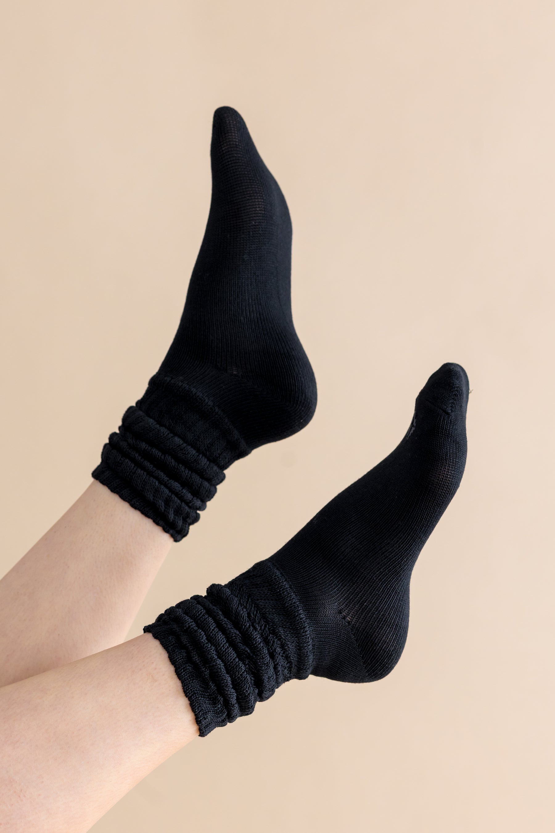 Adult Scrunch Socks in Midnight shown on a models feet in the air in front of a cream background