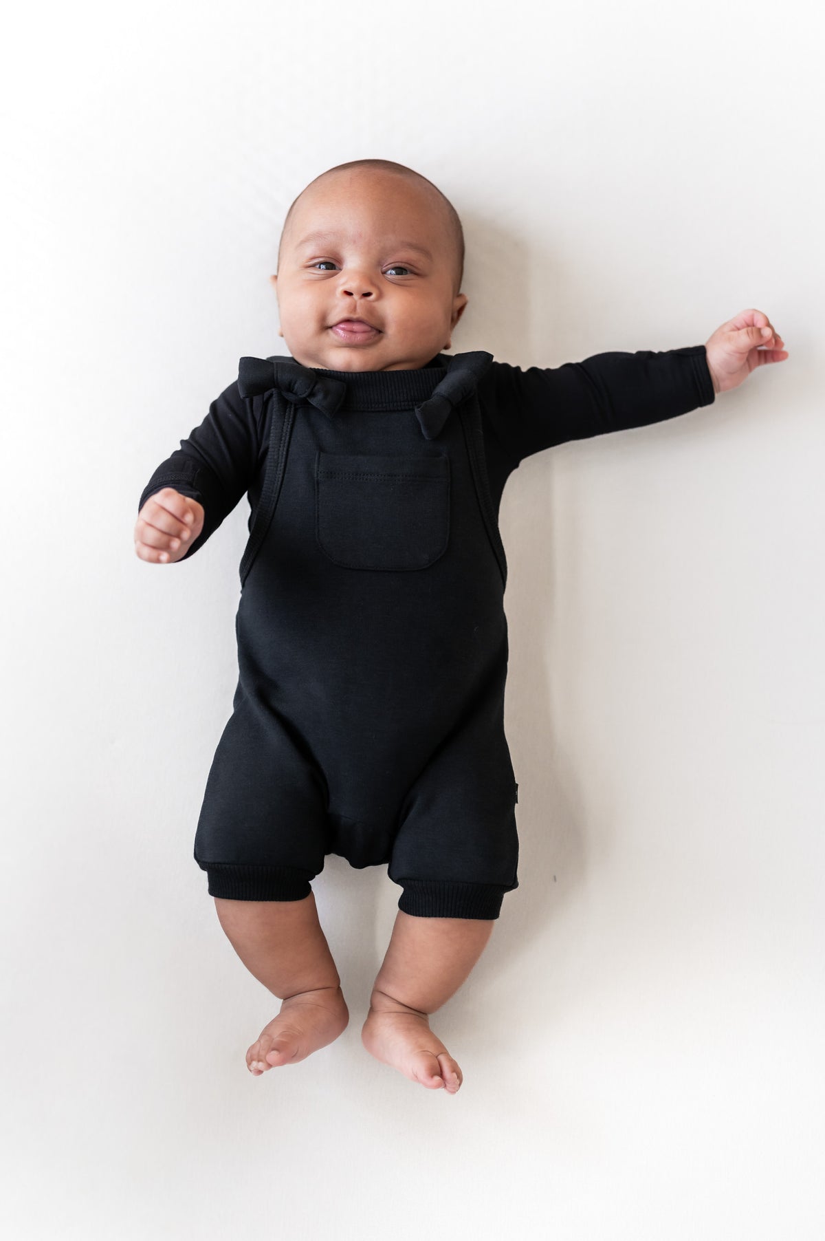 Baby wearing Overall in Midnight color on a beige background