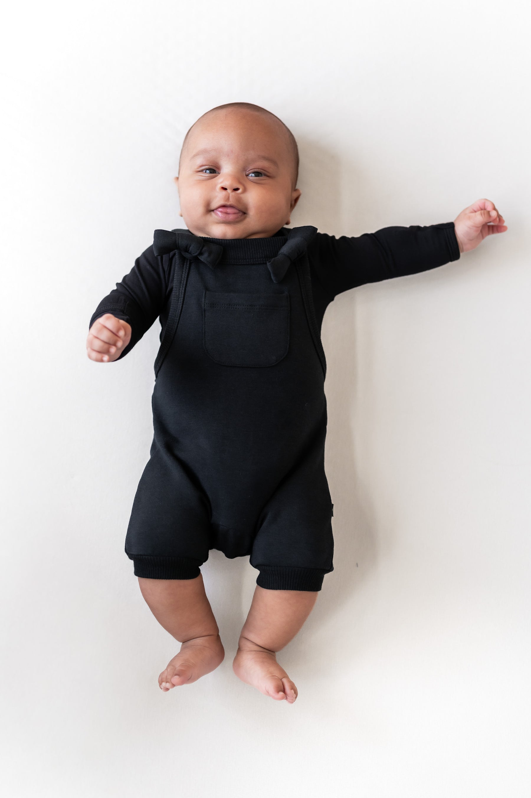 Baby wearing Overall in Midnight color on a beige background