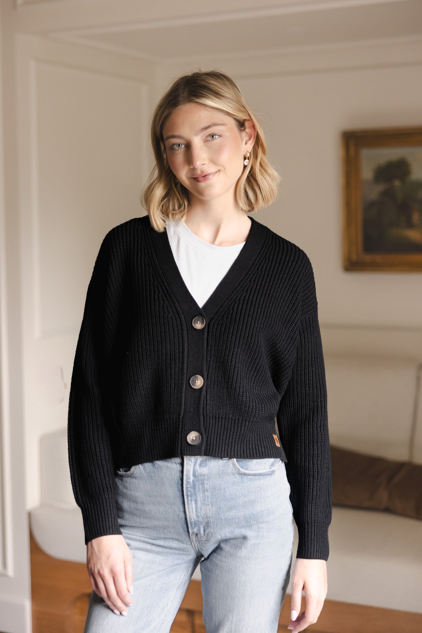 Modal wearing Chunky Knit Women's Cropped Cardigan in Midnight over white T-shirt and Blue jeans