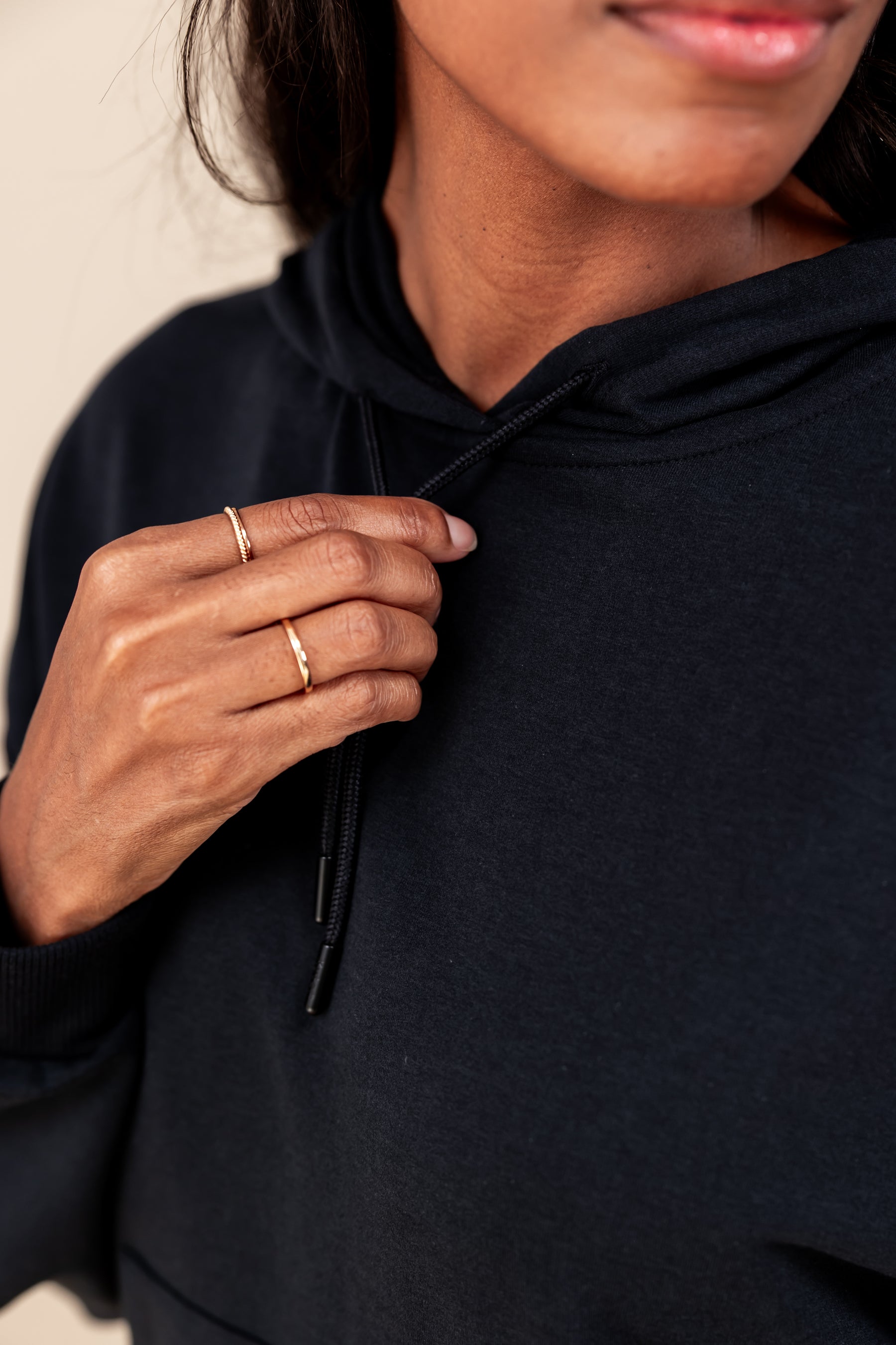 close up of Woman wearing Women's Hoodie in Midnight color on a beige background