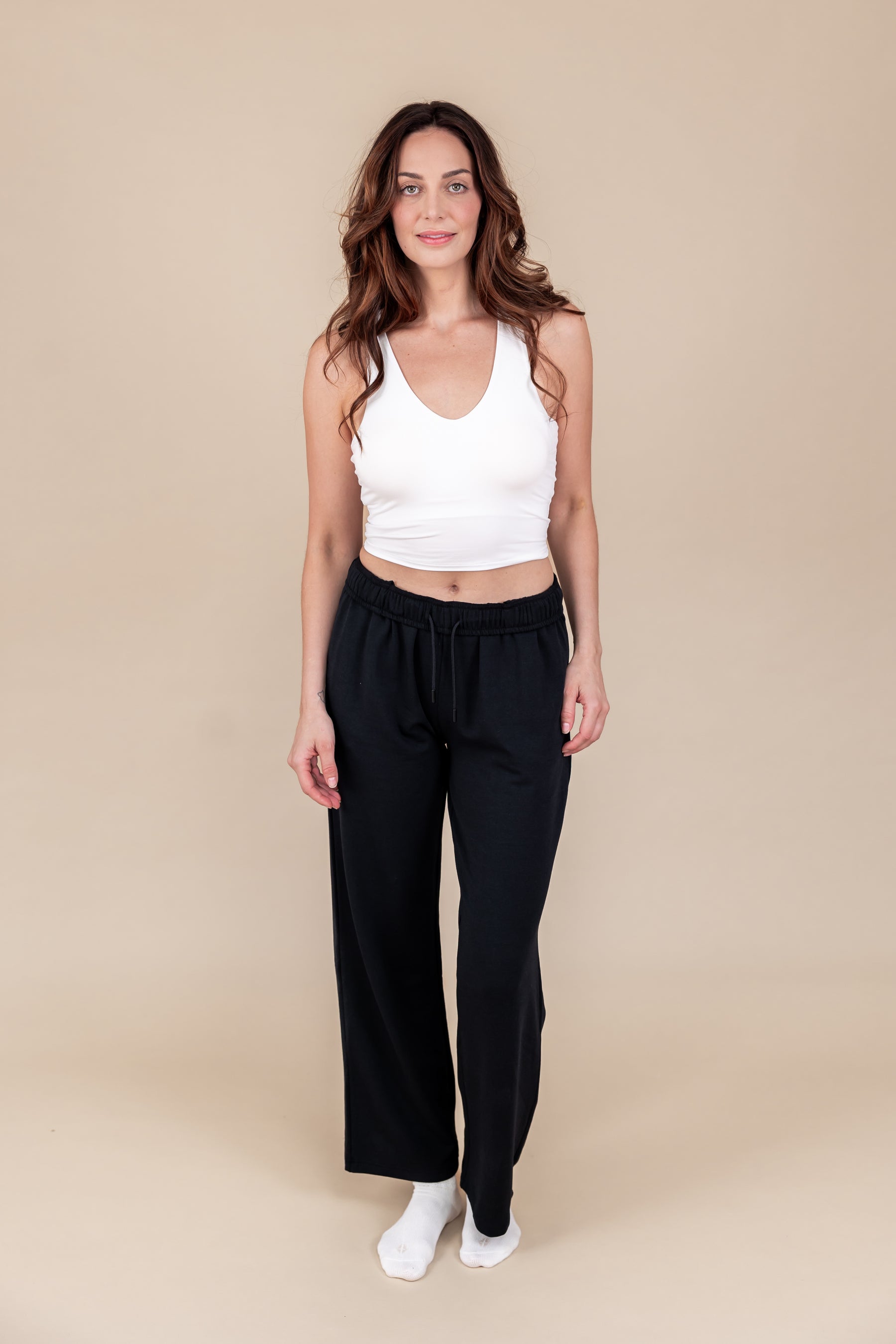 Modal wearing Women's Sweatpants in Midnight color under white flex bra tank on a beige background
