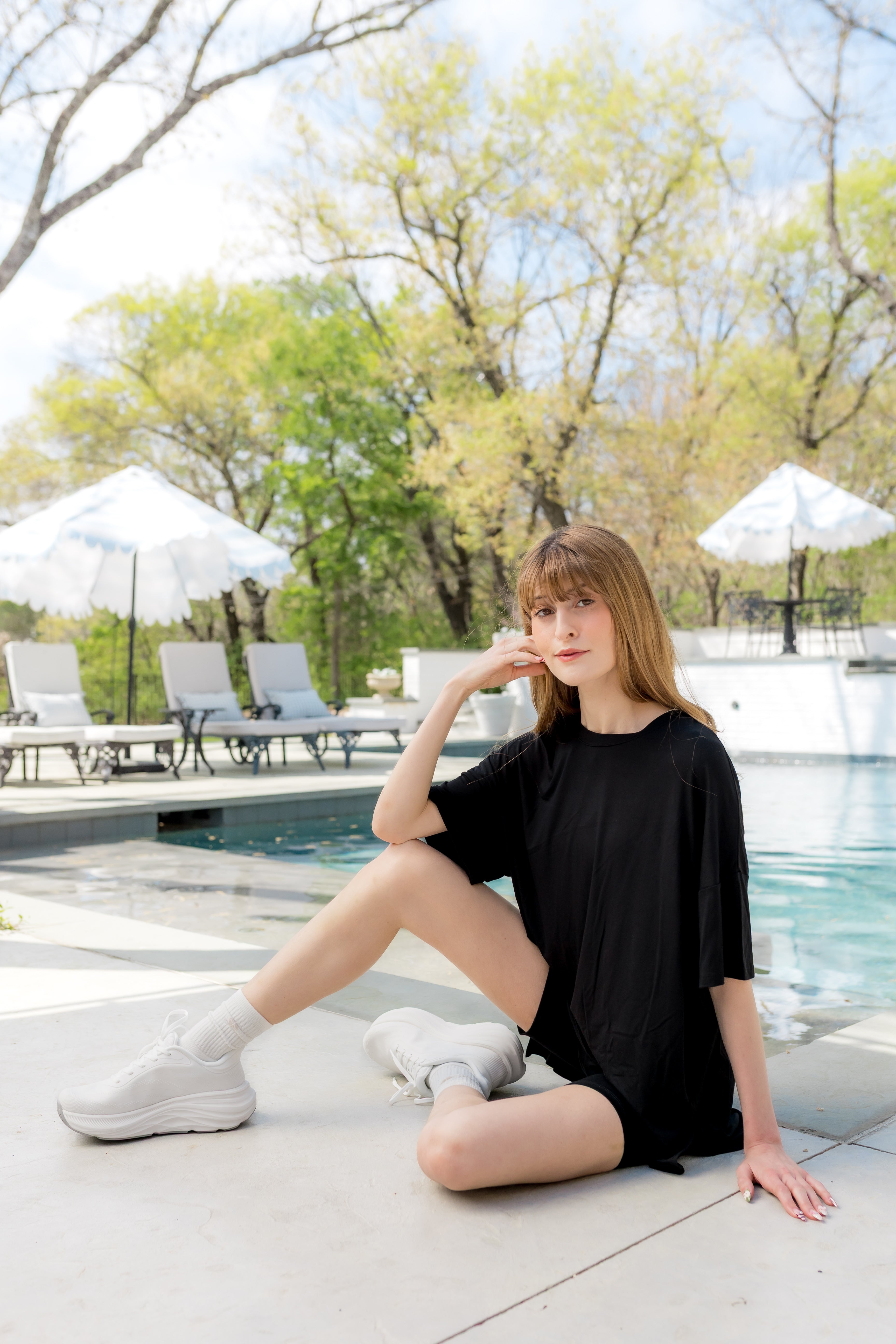 Female sitting by the pool's edge wearing the Women’s Biker Short Set in Midnight