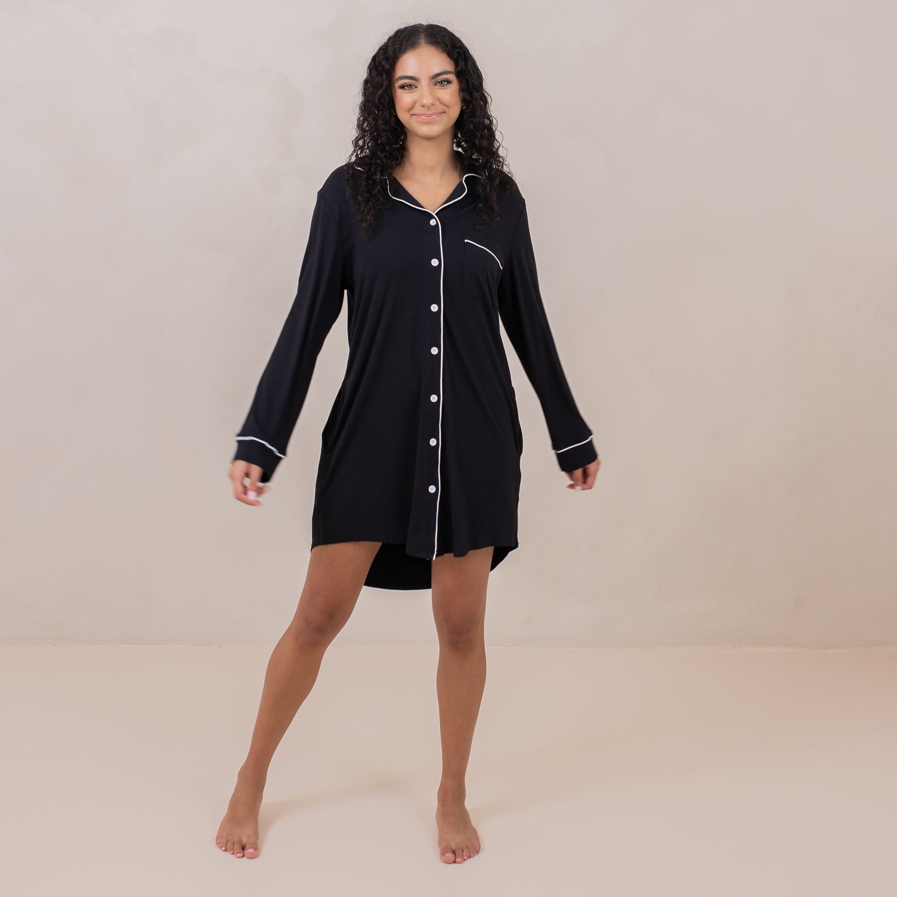 Female standing wearing the Long Sleeve Women’s Nightshirt in Midnight in front of a light taupe backdrop