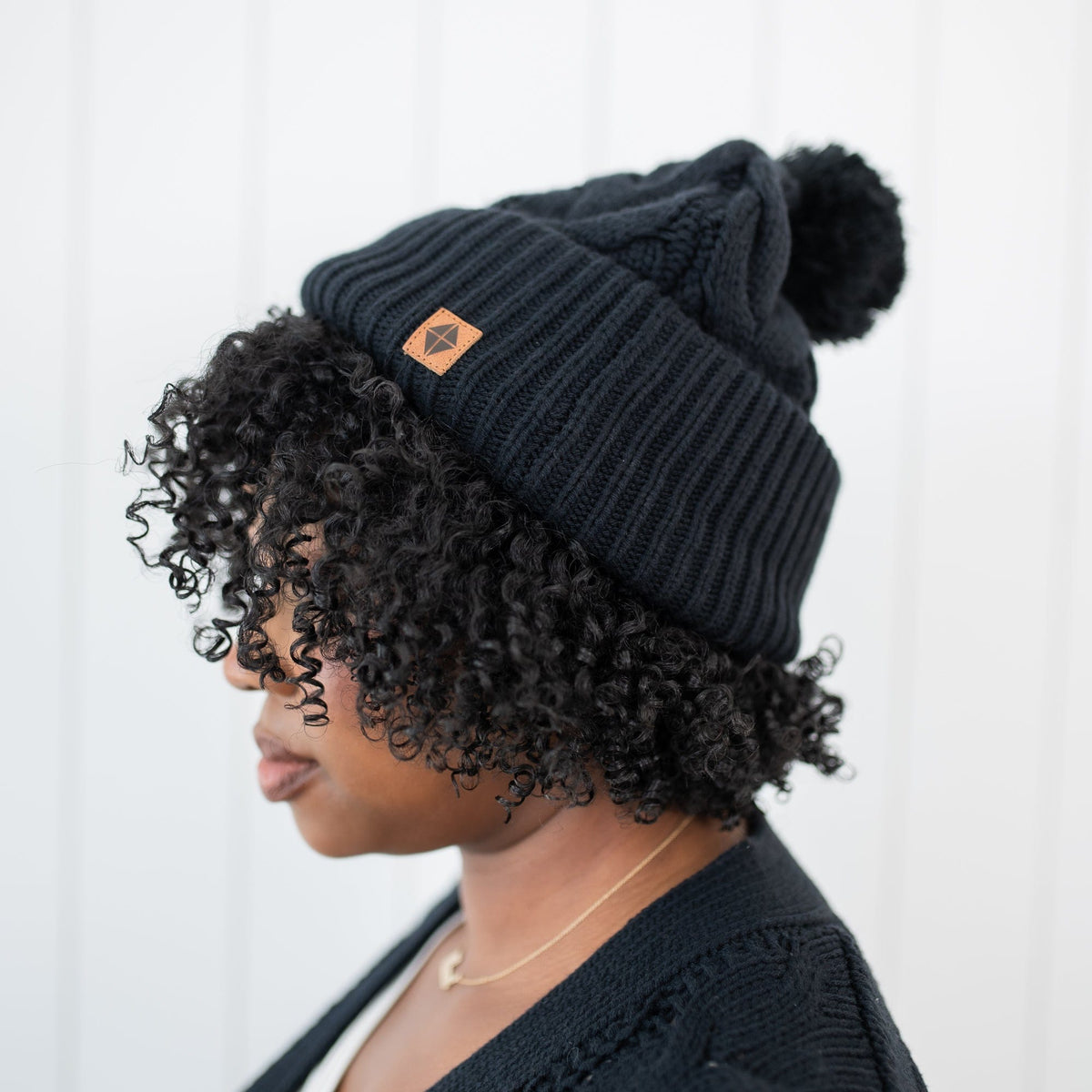 Cable Knit Adult Pom Beanie in Midnight shown on a female model