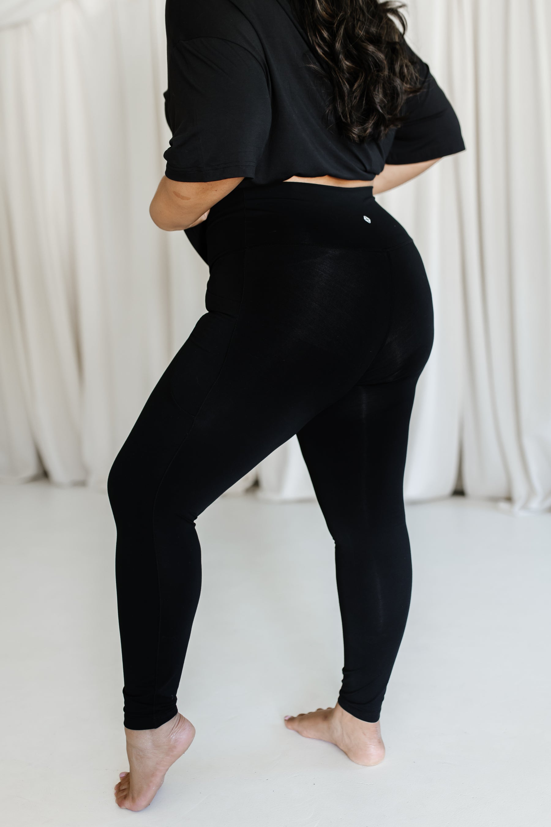 The side view of the Bamboo Flex Women’s Leggings in Midnight shown on a female model