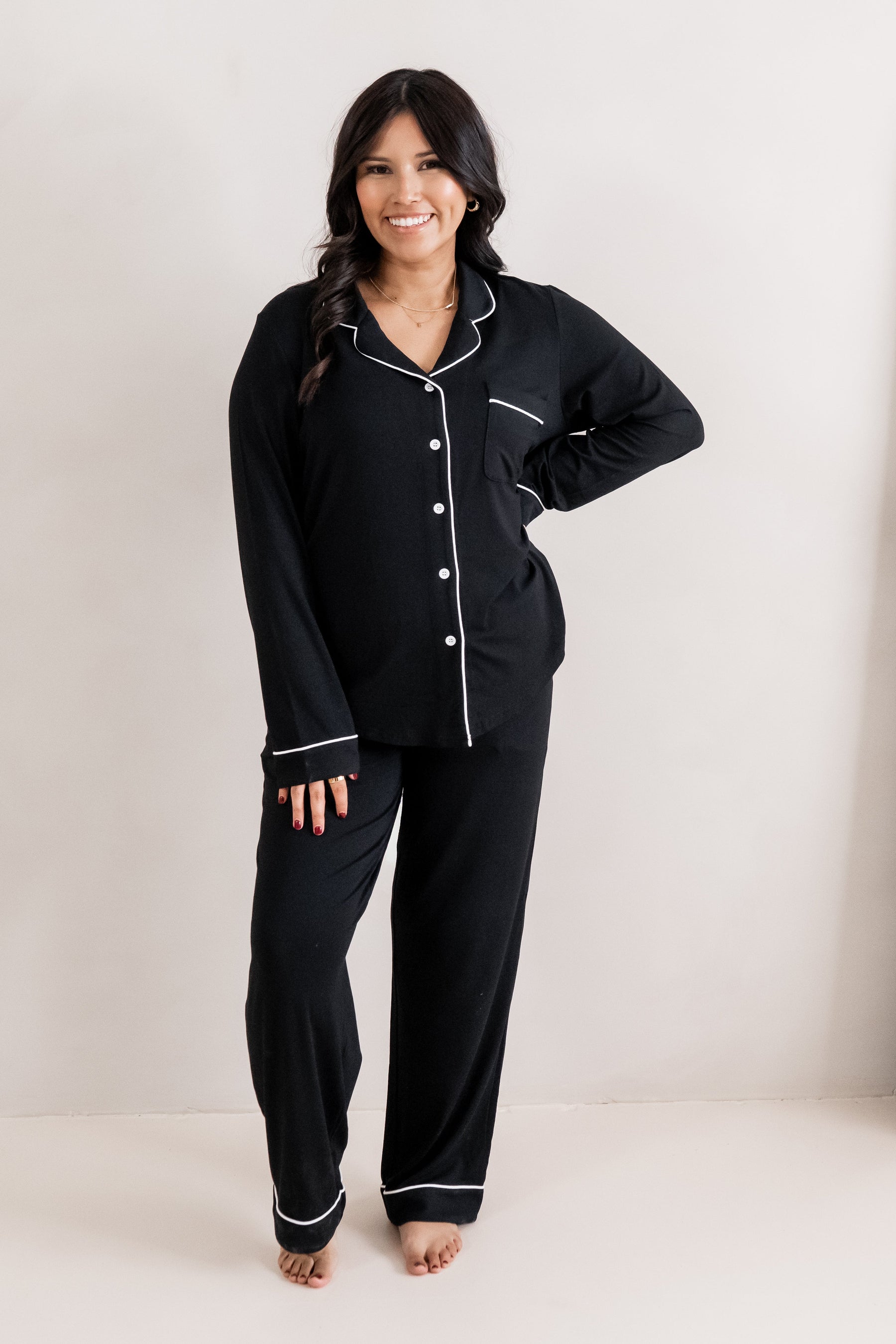 Female standing with one hand on her hip wearing the Long-Sleeved Women's Pajama Set in Midnight with Cloud Trim