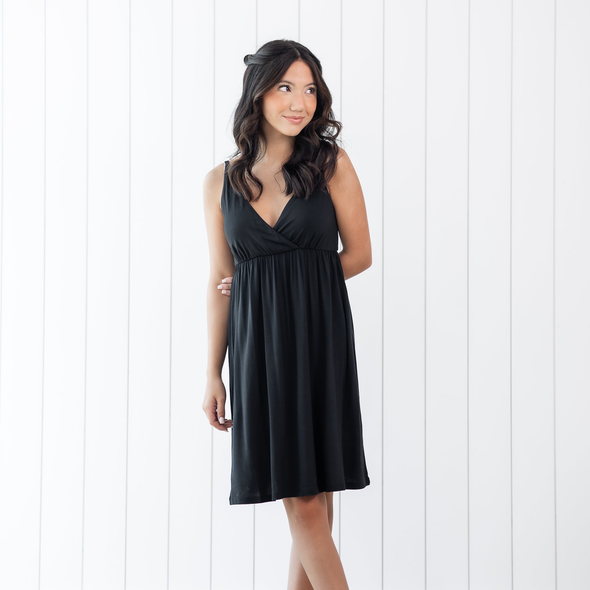 Woman wearing a black nightgown against a white background