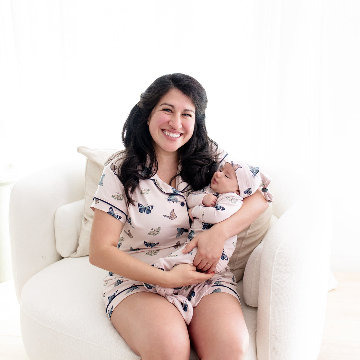 Mom wearing Women’s Short Sleeve Pajama Set in Blush Butterfly holding baby in matching knotted gown set