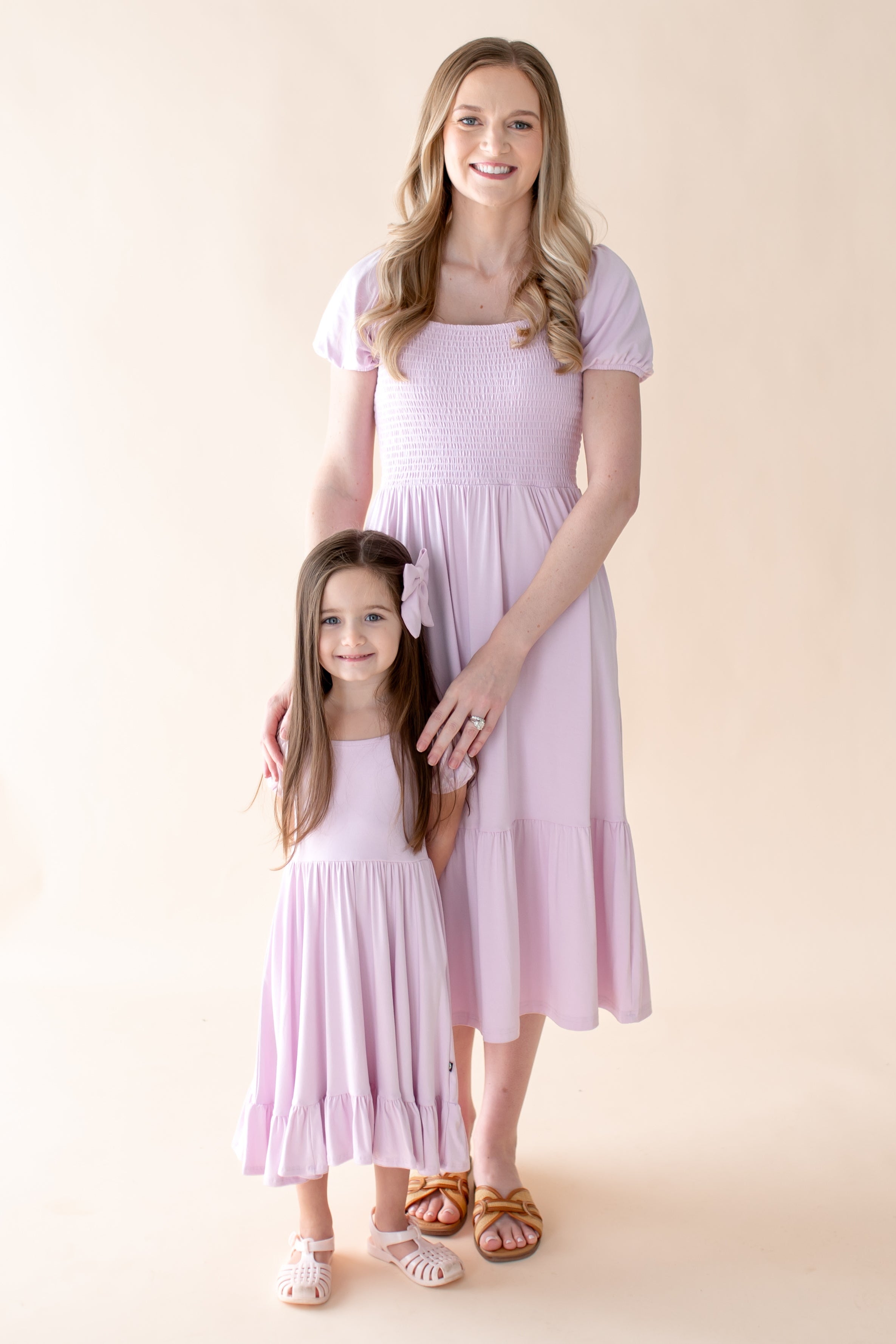 Mom and child wearing matching light purple puff sleeve smocked dresses