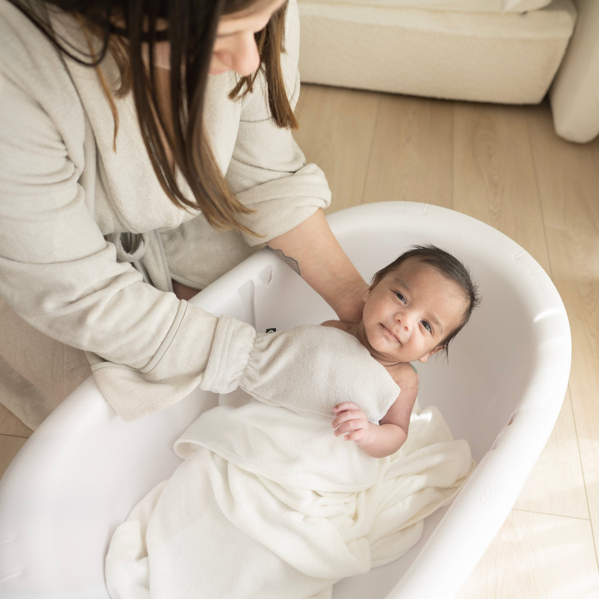 Mom using Bamboo Terry Bath Mitt in Oat to Bathe Newborn