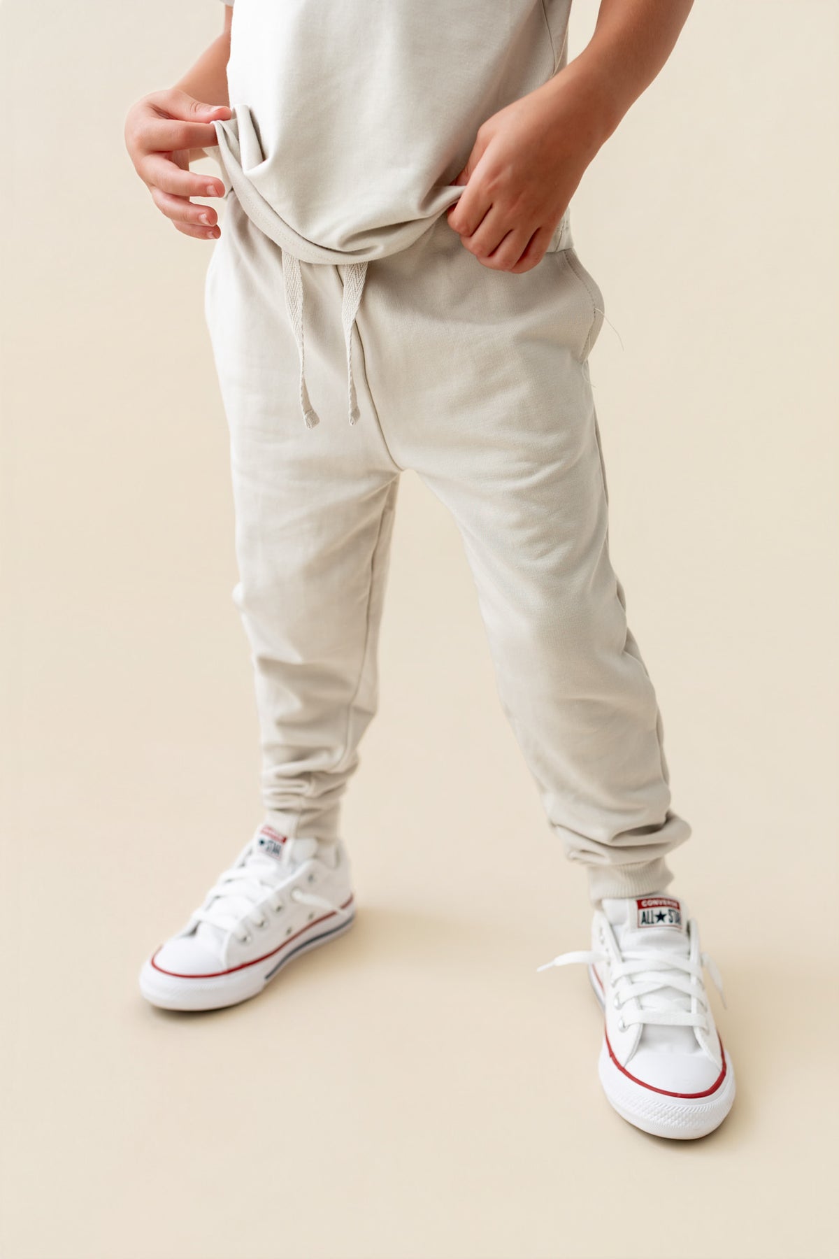 Modal wearing Jogger Pant in Oat color under similar color shirt on a beige background