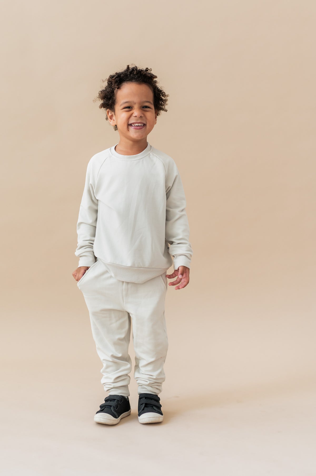 Boy wearing Long Sleeve Jogger Set in Oat color on a beige background