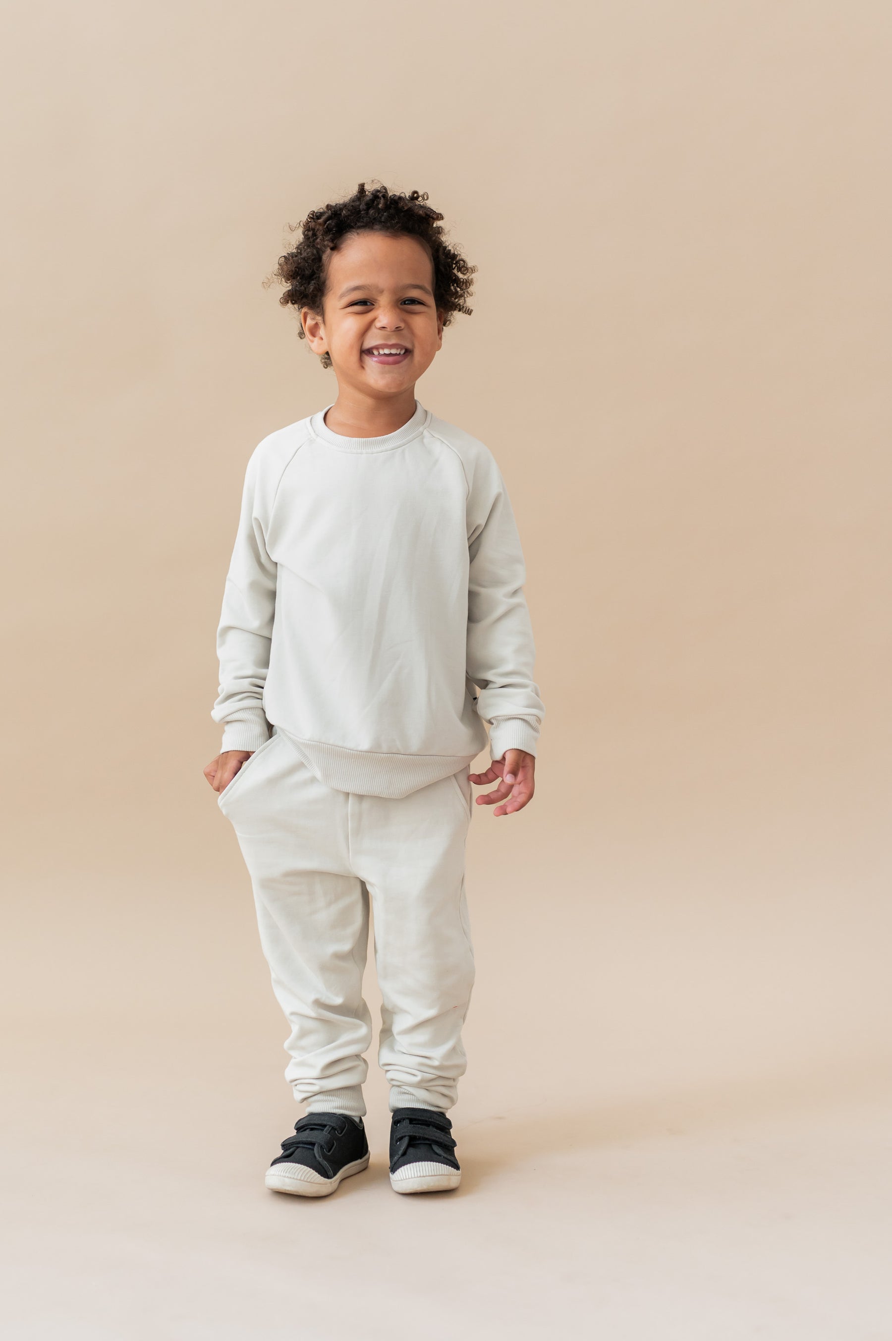 Boy wearing Long Sleeve Jogger Set in Oat color on a beige background
