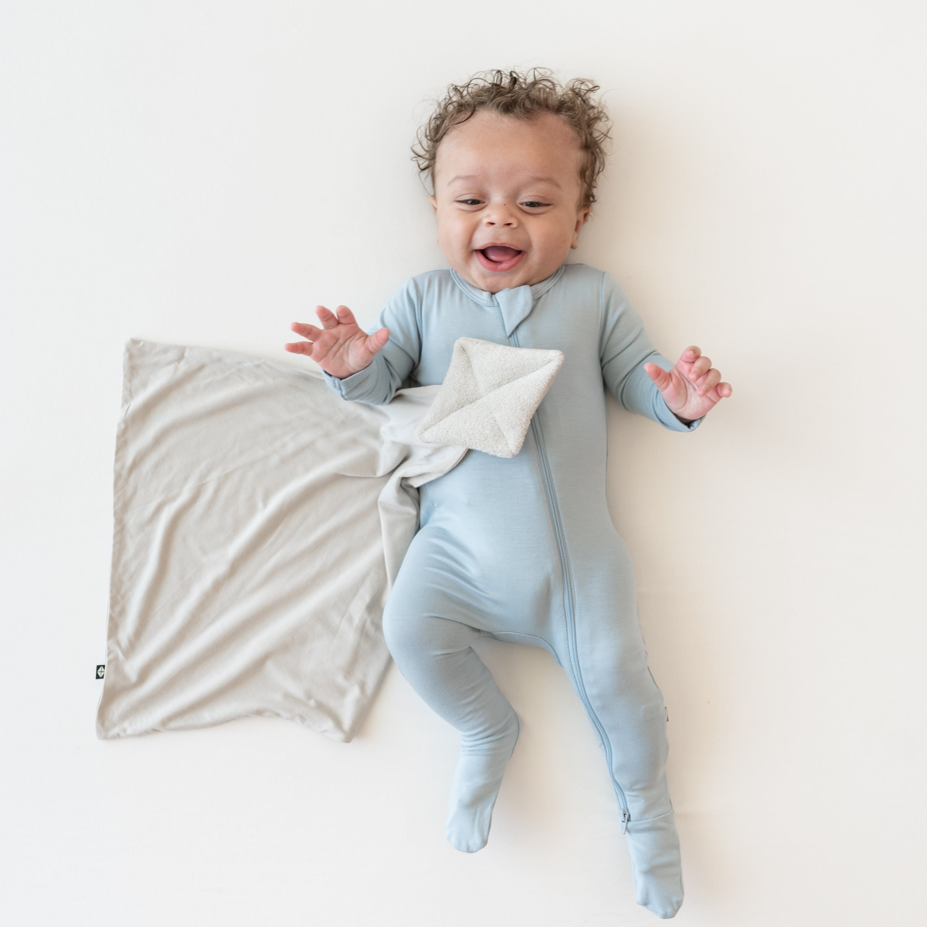 Baby in fog zippered footie with Kite Lovey in Oat 