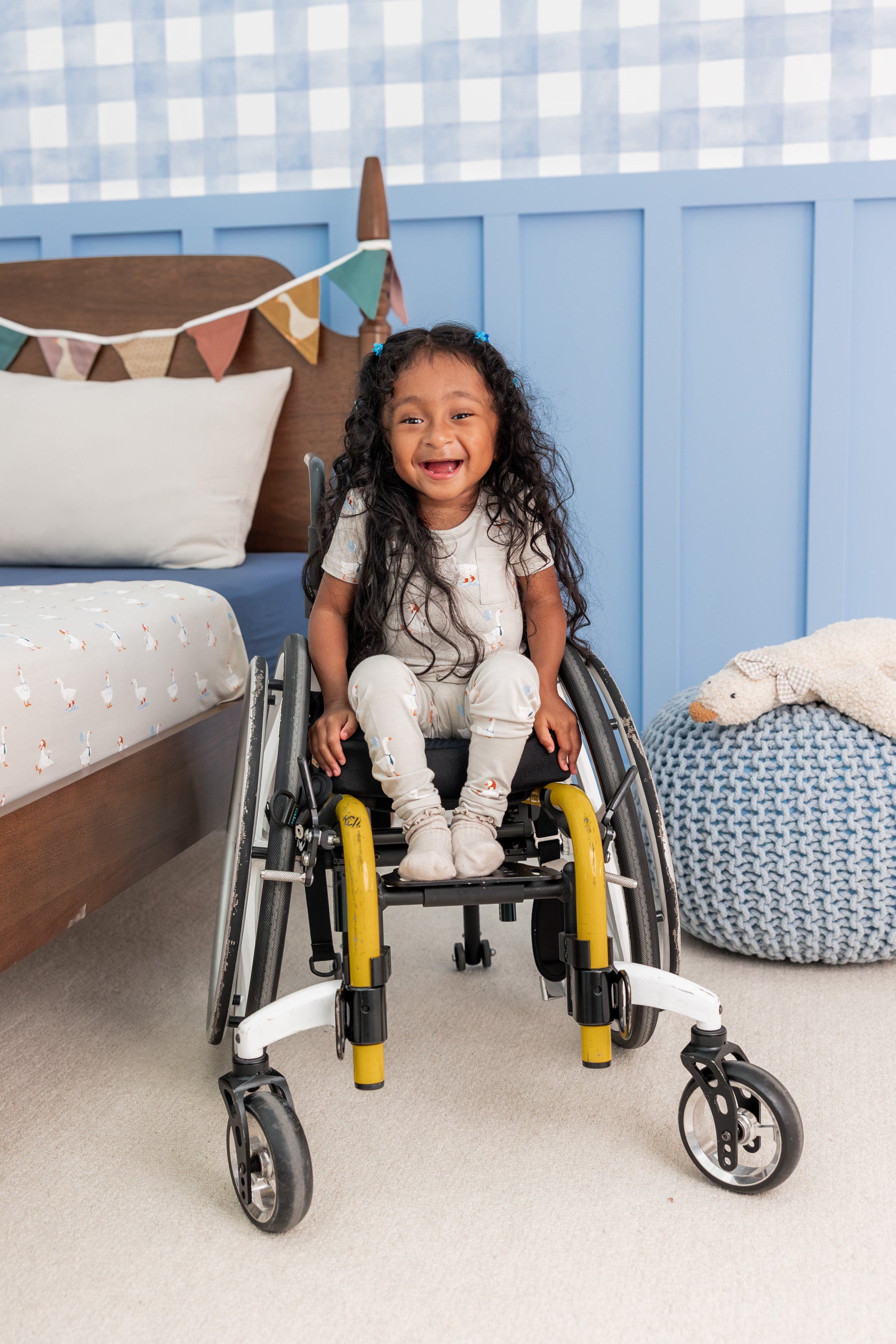 Toddler wearing Short Sleeve with Pants Pajamas in Oat Silly Goose print sitting on a wheel chair