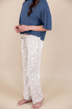 Woman wearing Women's Lounge Pants in Oat Silly Goose print over oxford color T-shirt on a beige background