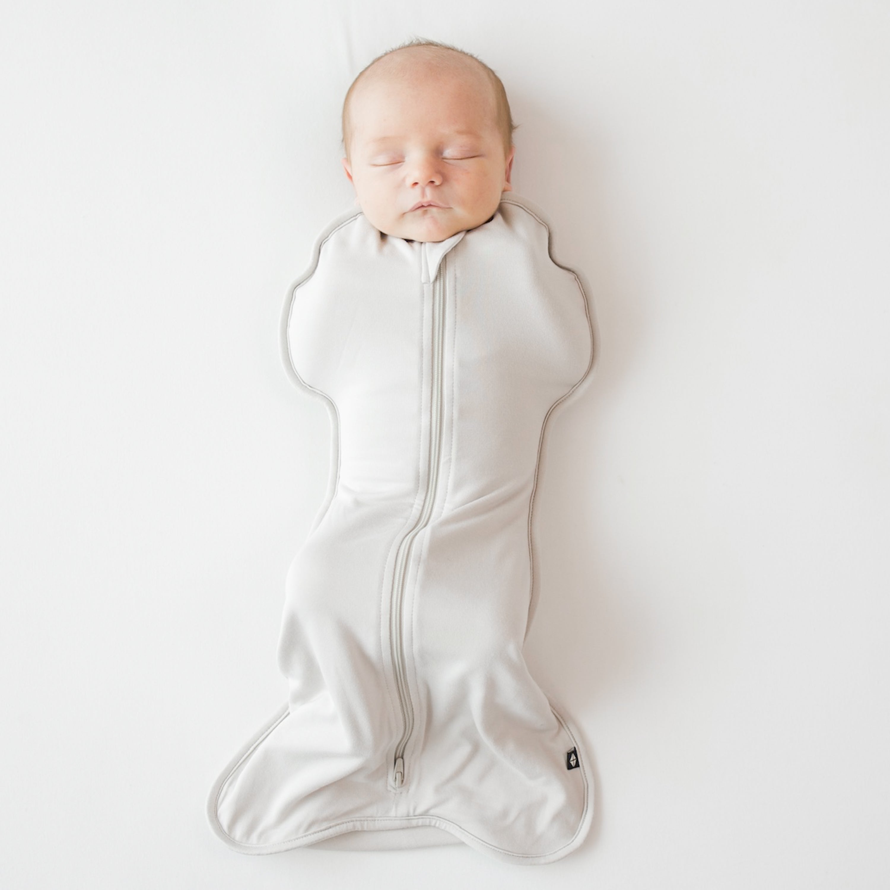 Baby sleeping in Kyte Baby Swaddle Bag in Oat 0.5